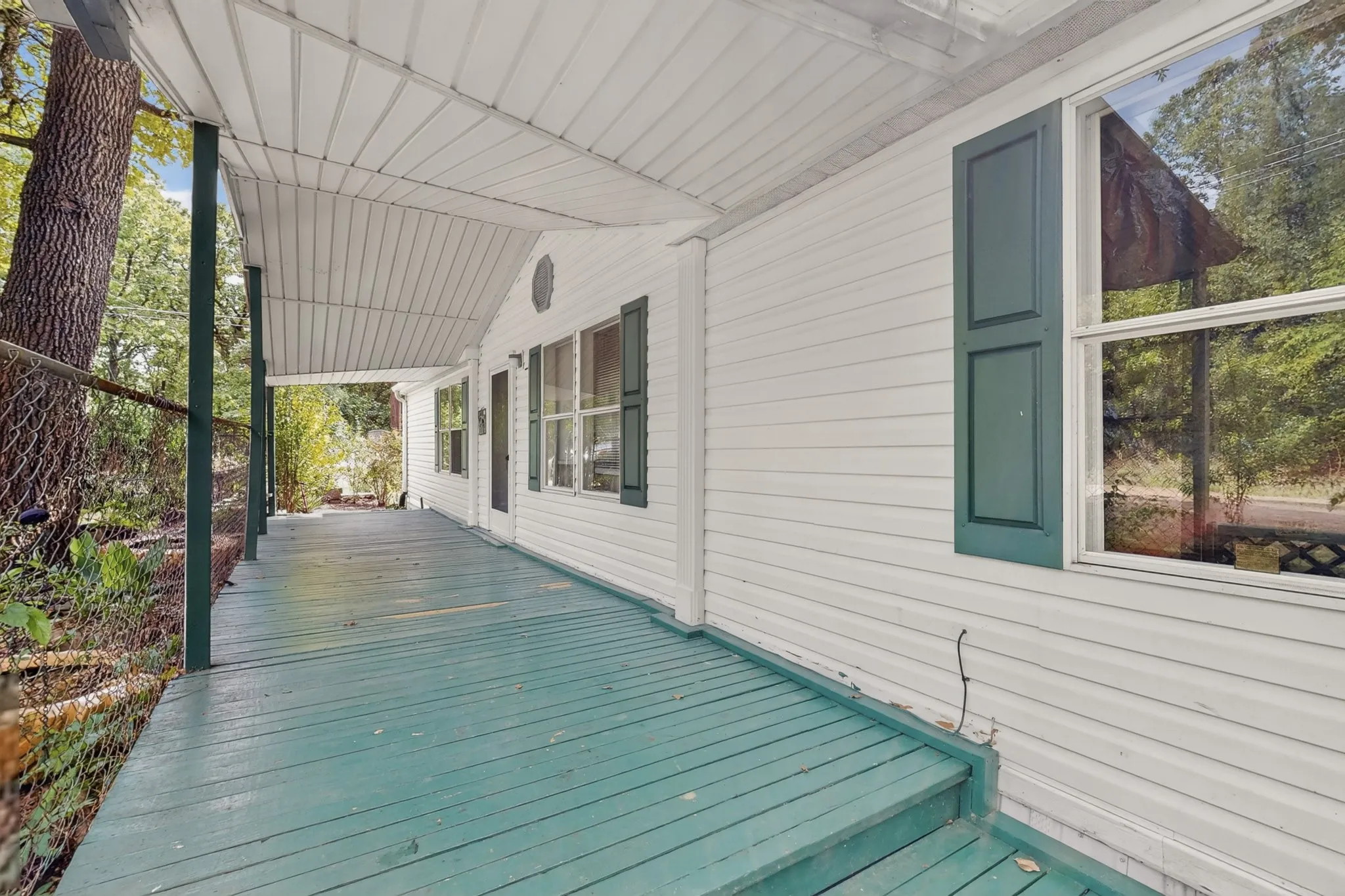 The property features a covered porch with a painted teal floor and a white ceiling
