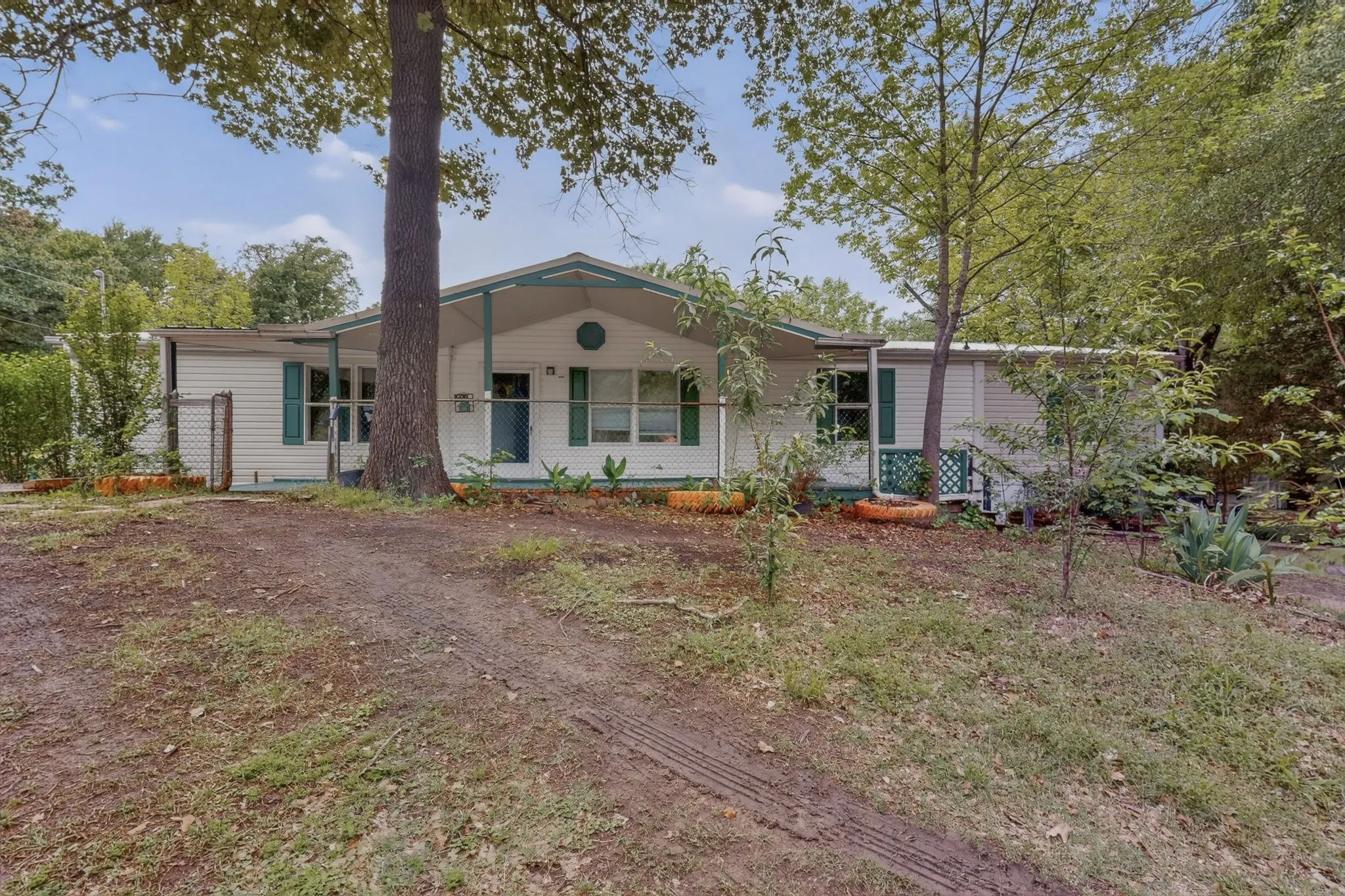 The property features a white exterior with green shutters and a covered front porch