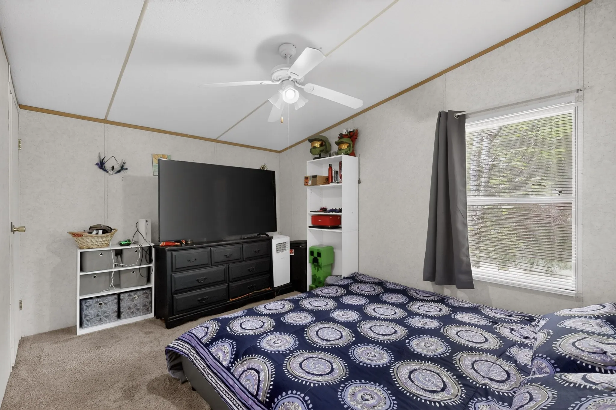 The property features a room with carpeted floors, a ceiling fan, and a window with blinds providing natural​​‌​​​​‌​​‌‌​‌‌​​​‌‌​‌​‌​‌​​​‌​​ light