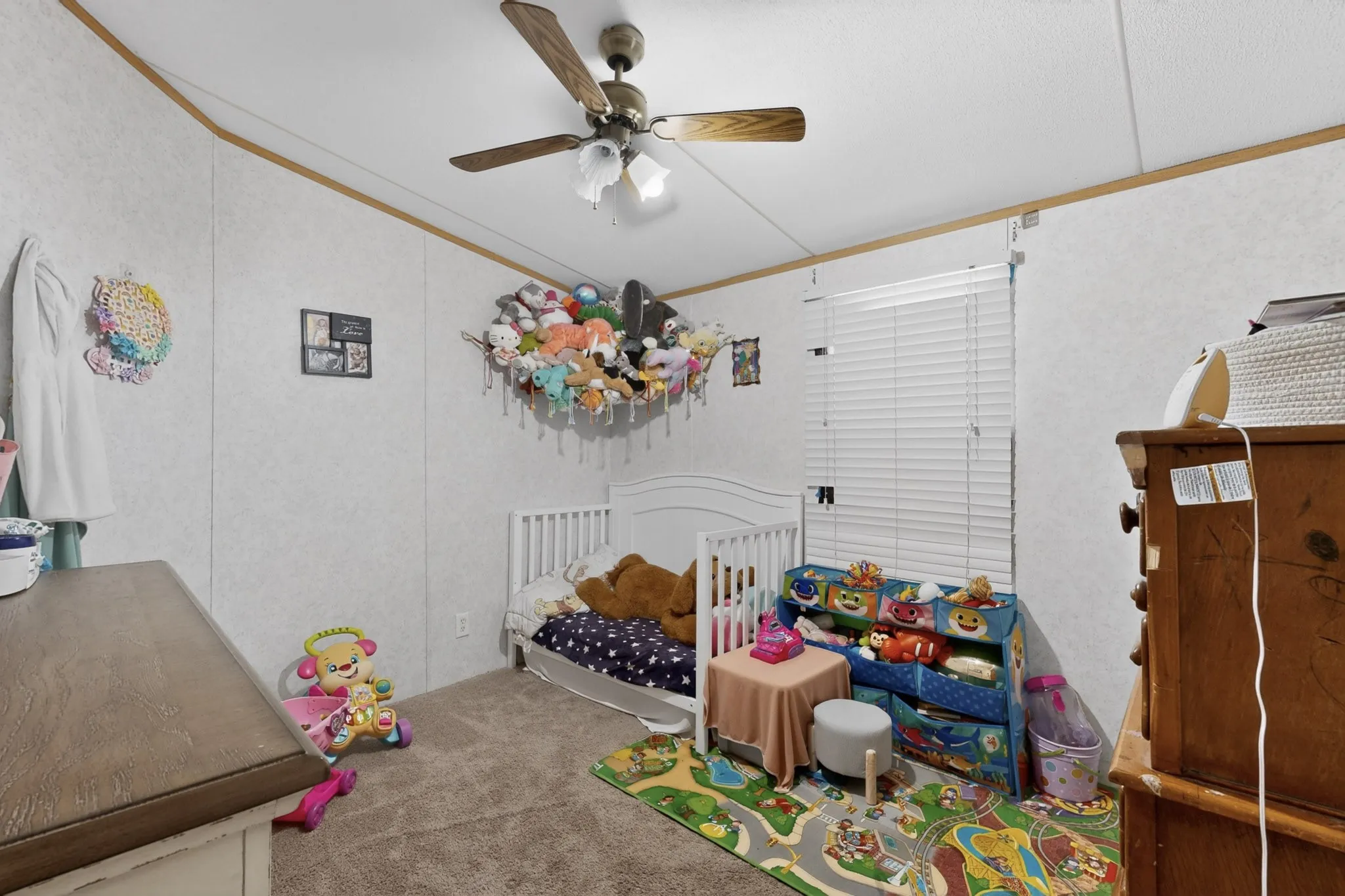 This room features white walls, a ceiling fan, and carpeted flooring