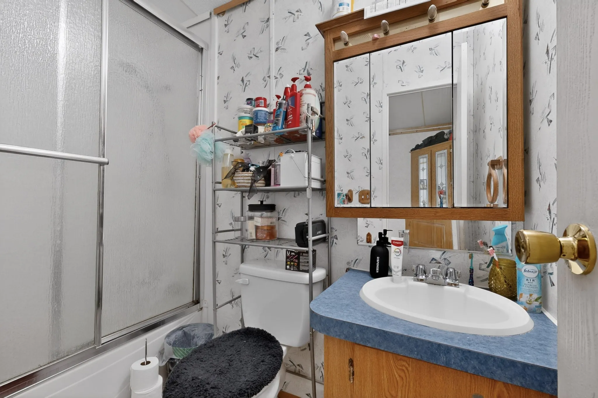Bathroom featuring a shower with a frosted glass enclosure and a vanity with a blue countertop and an integrated sink