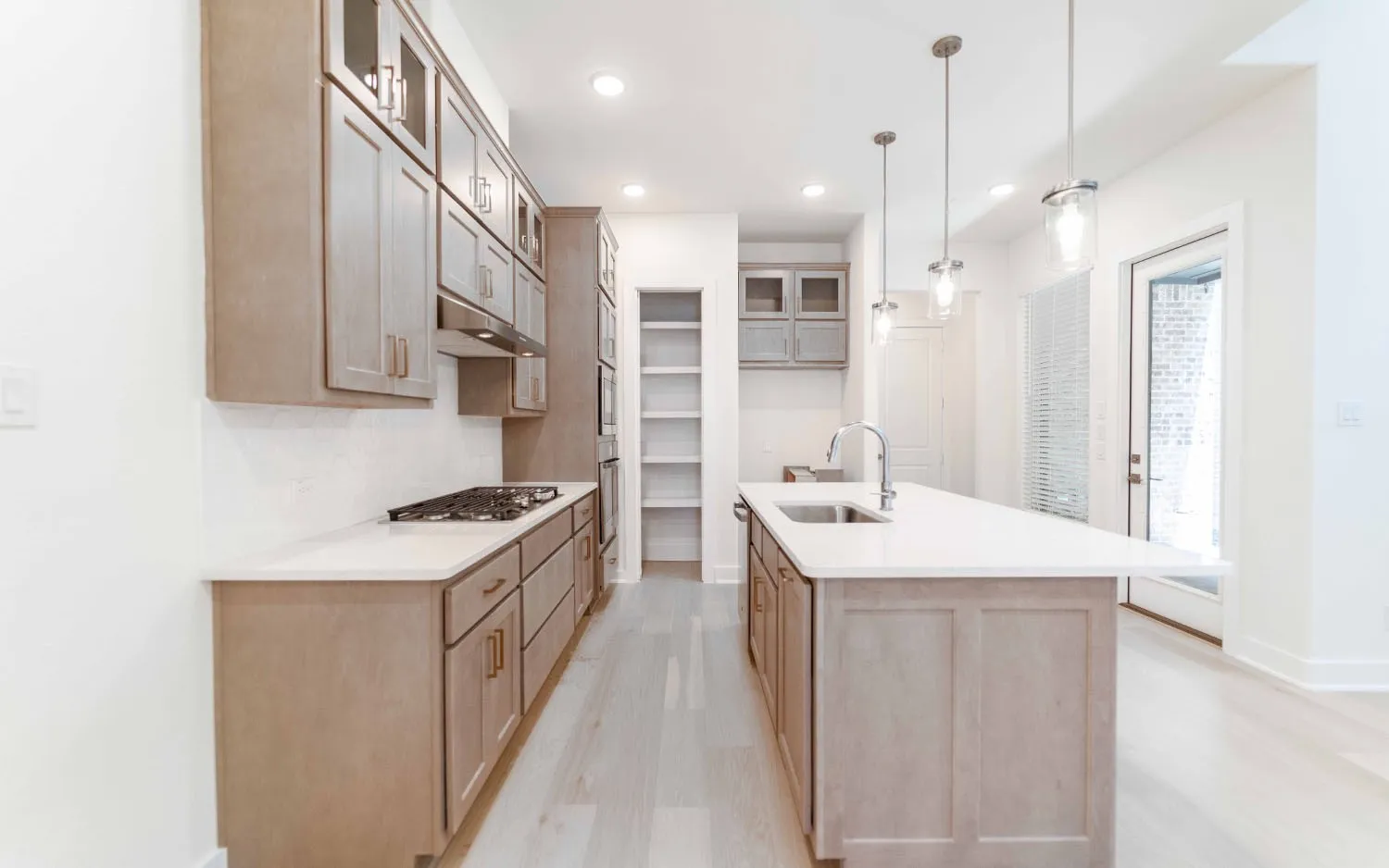 Kitchen featuring wood-finish cabinetry, light-toned countertops, and light wood-finish flooring