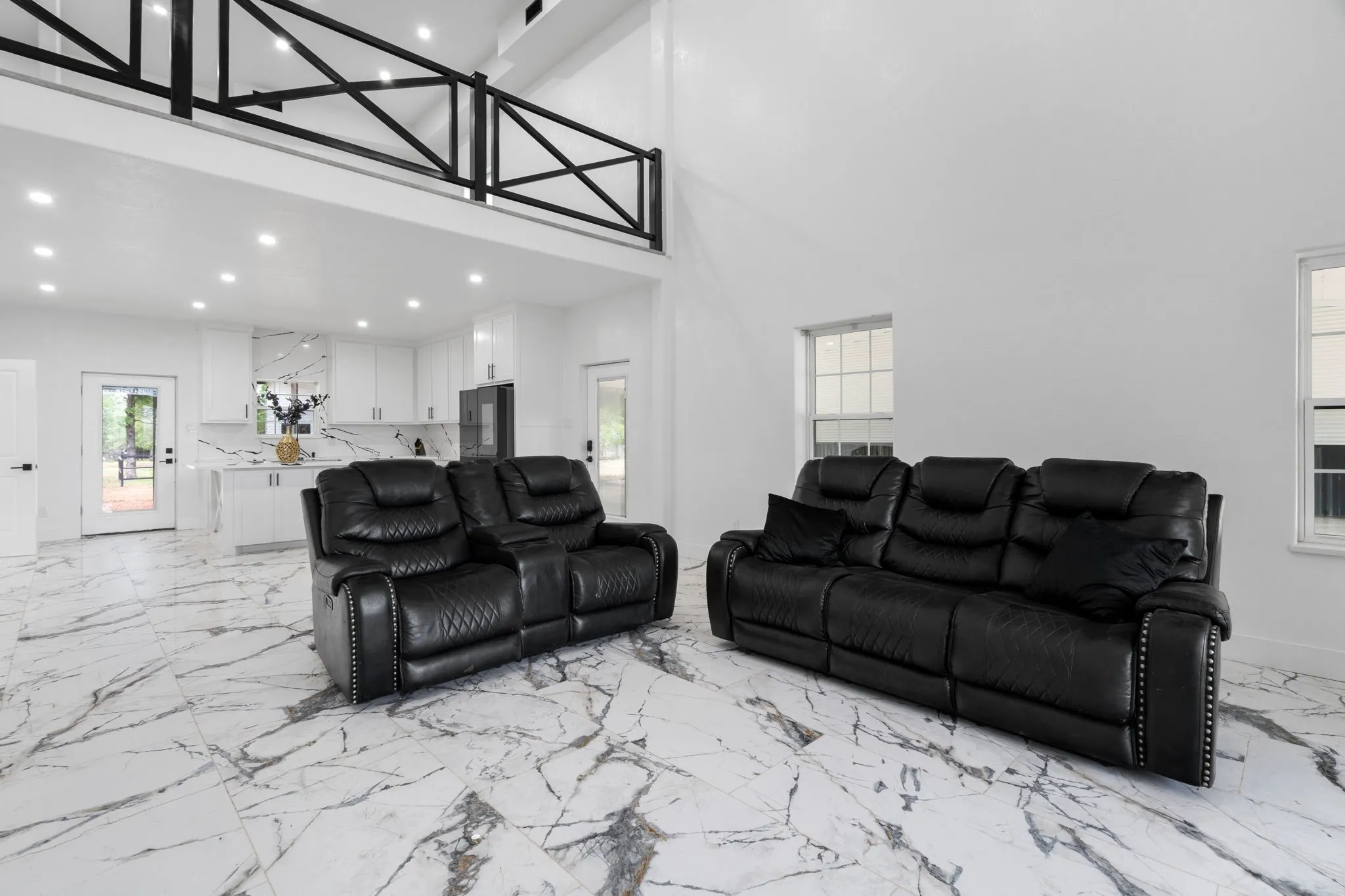 Open-concept living area with high ceilings and a second-story balcony