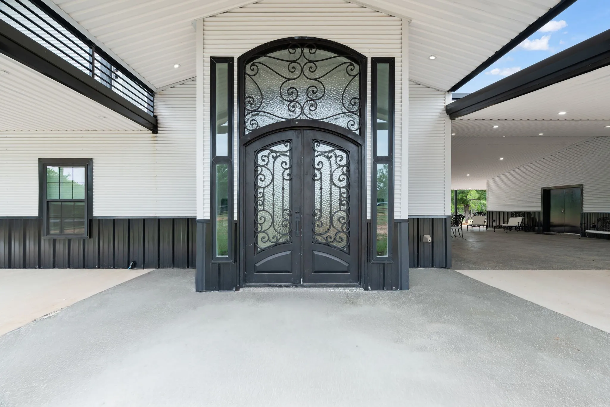 Iron-wrought double entry doors with decorative glass and transom window