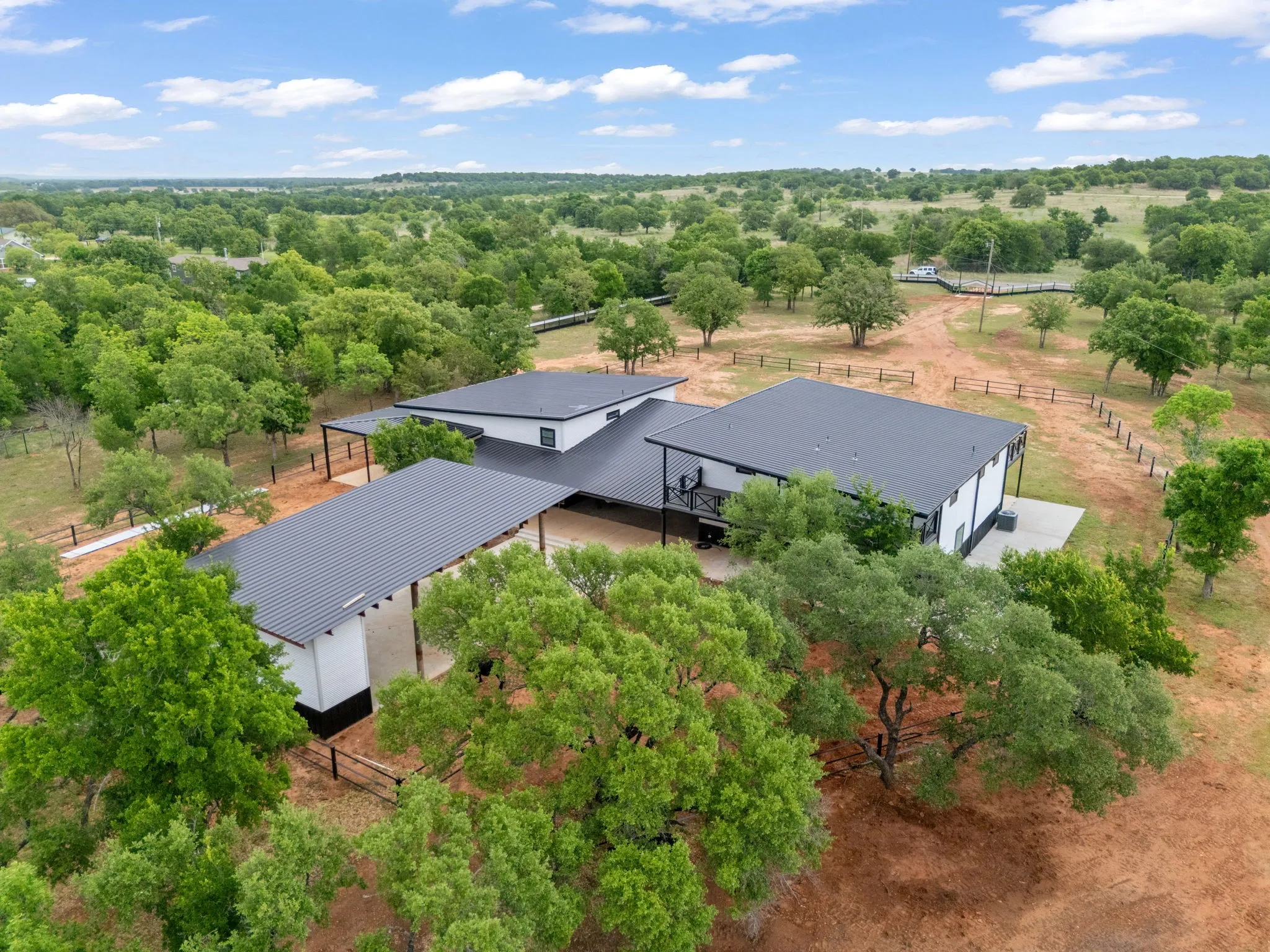 Modern single-story dwelling with white and black exterior accents, complemented by a dark metal roof