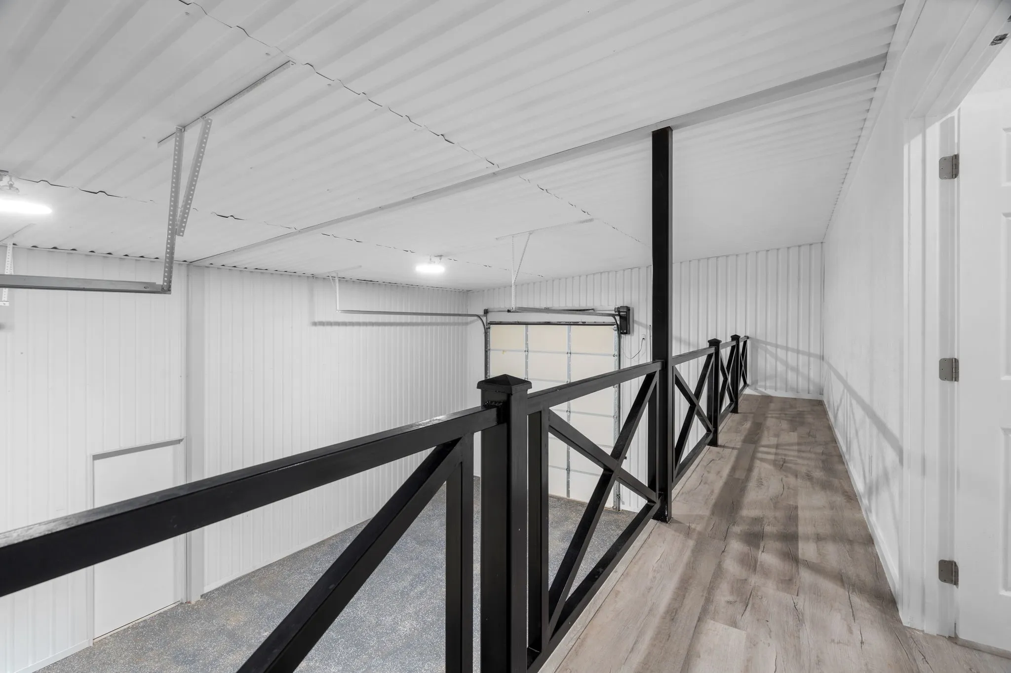 Guest Quarters shop Upper-level walkway featuring wood-finish flooring and black metal railings