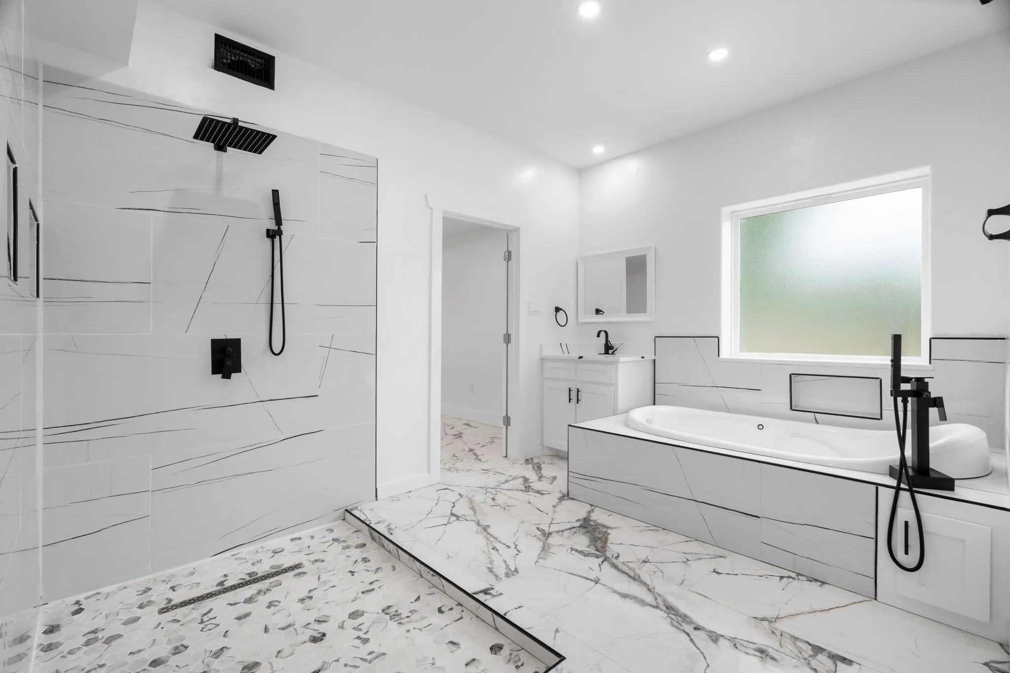 Spacious bathroom featuring a freestanding tub, walk-in shower, black fixtures, recessed lighting, and a window with frosted glass