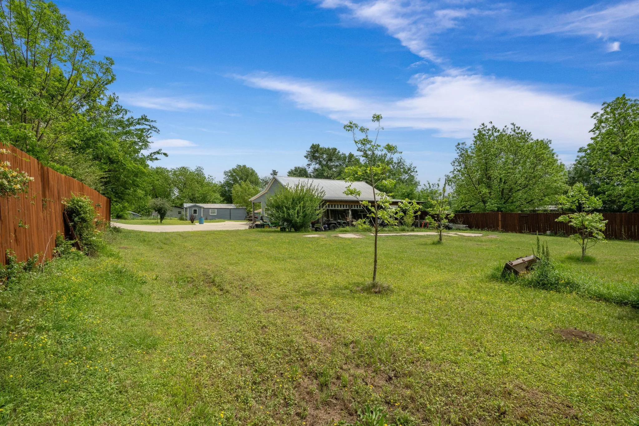 Spacious green lawn with a privacy fence bordering the property