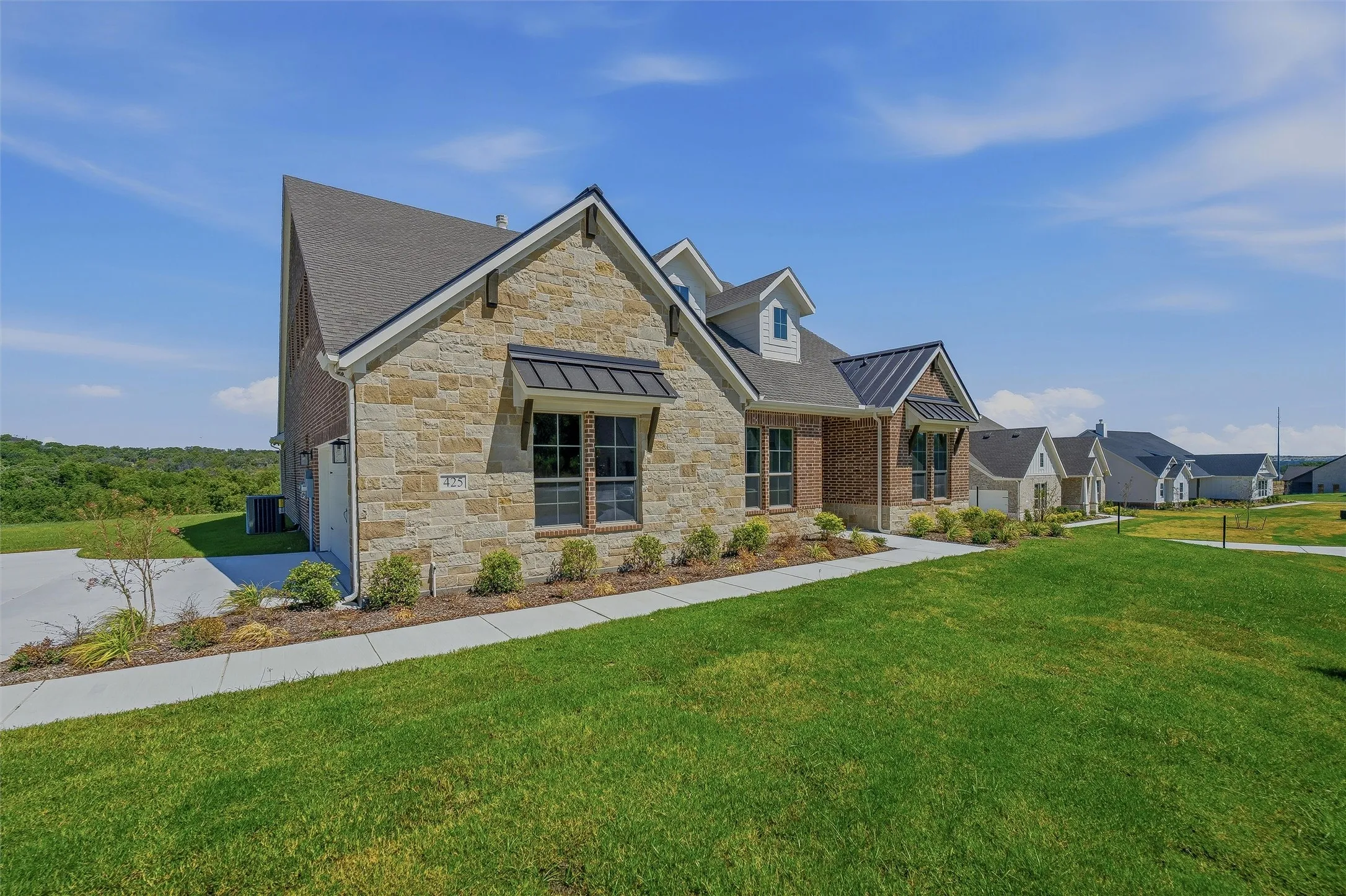 Stone and brick exterior with contrasting dark window awnings