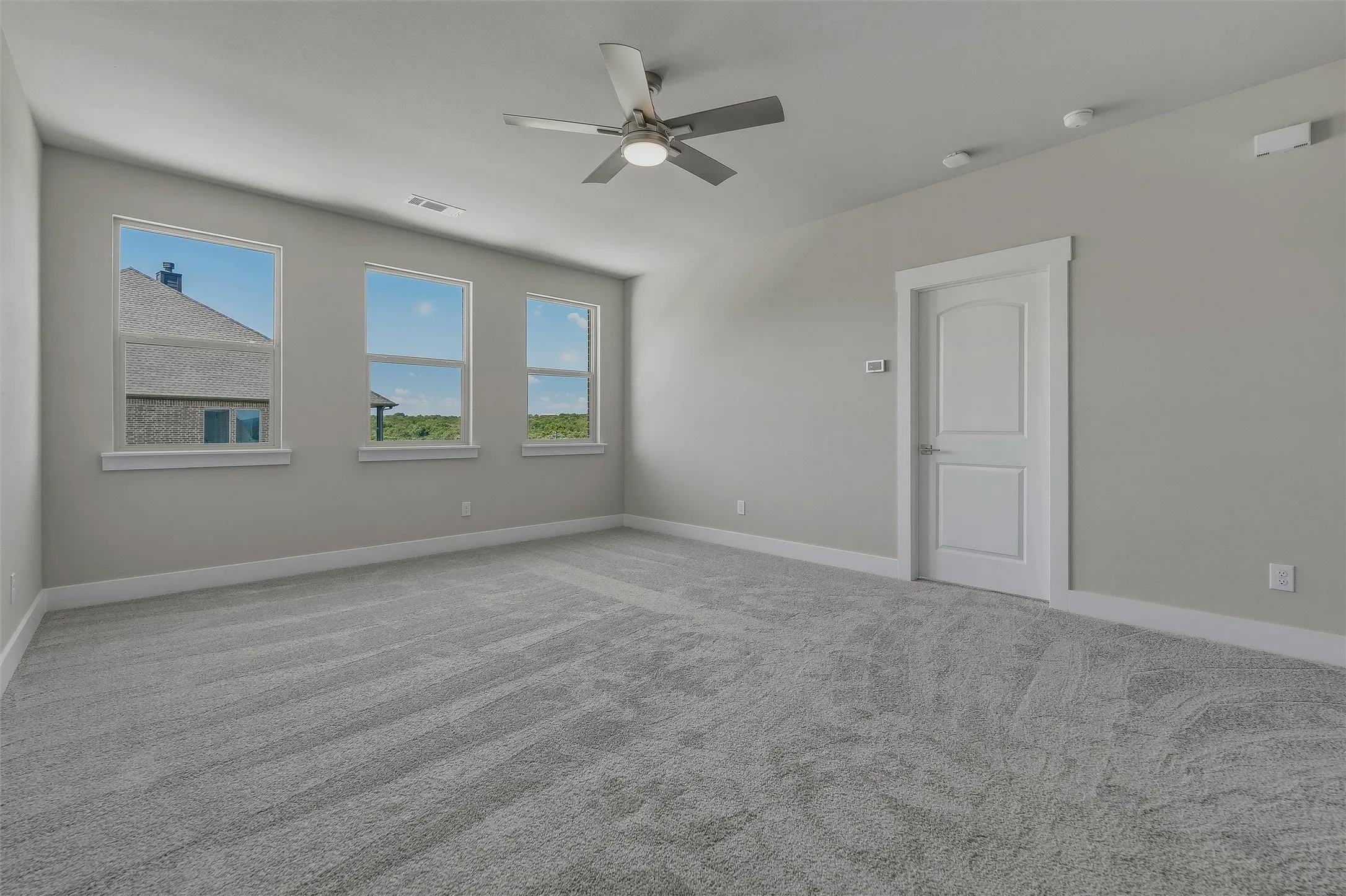 Room featuring three windows, a ceiling fan with integrated lighting, recessed lighting, and soft carpet flooring