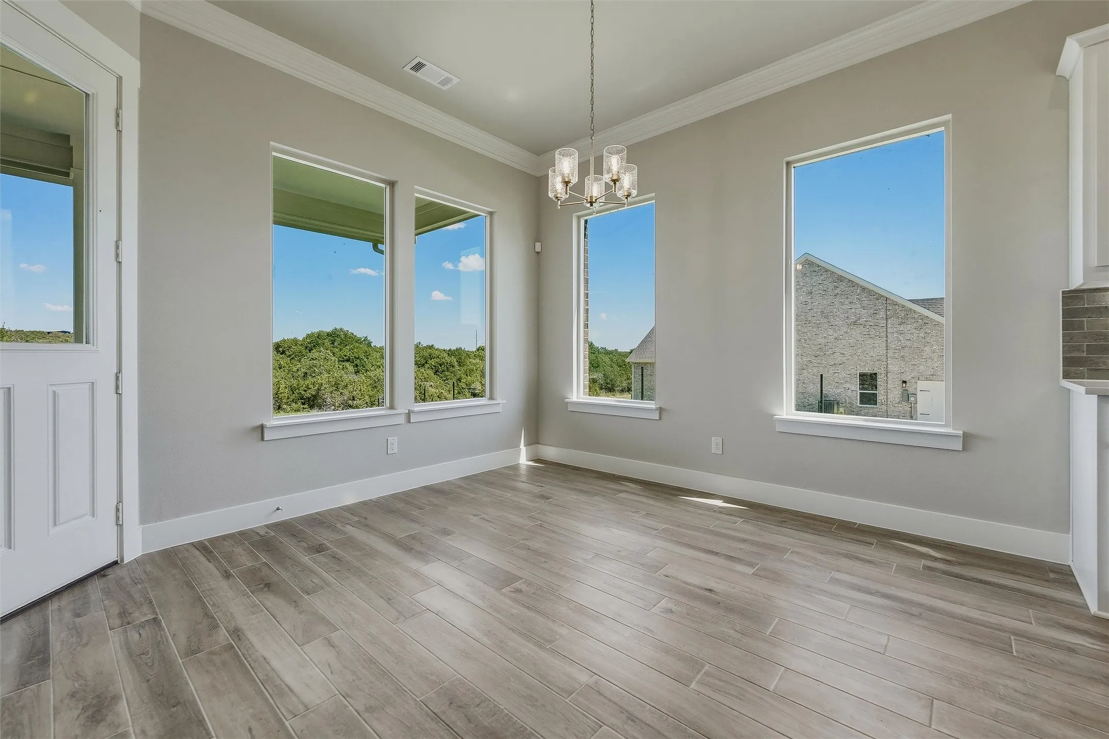 Recessed lighting, wood-finish flooring, multiple windows, and a modern chandelier