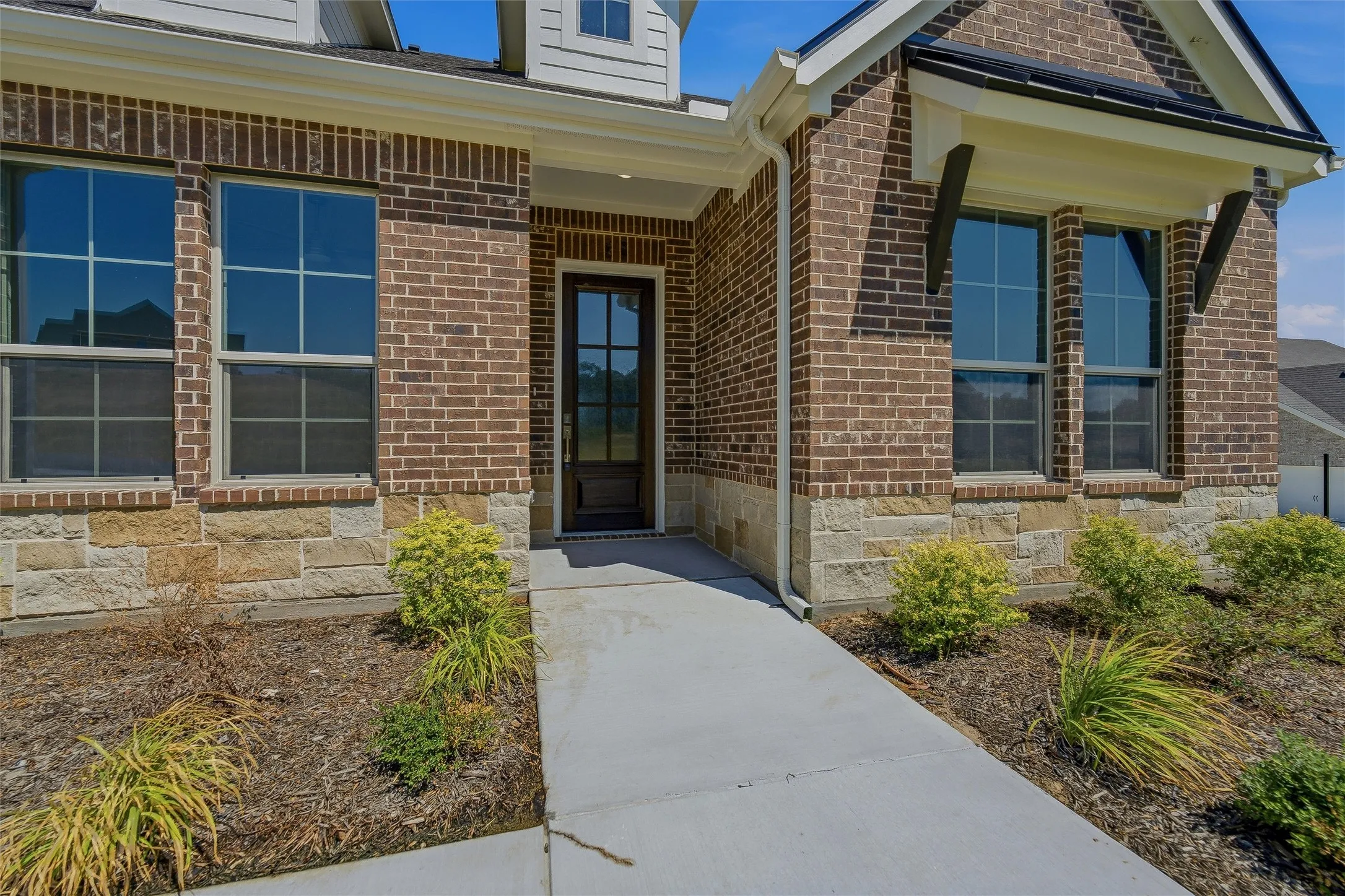 Brick and stone facade with an inviting entry door
