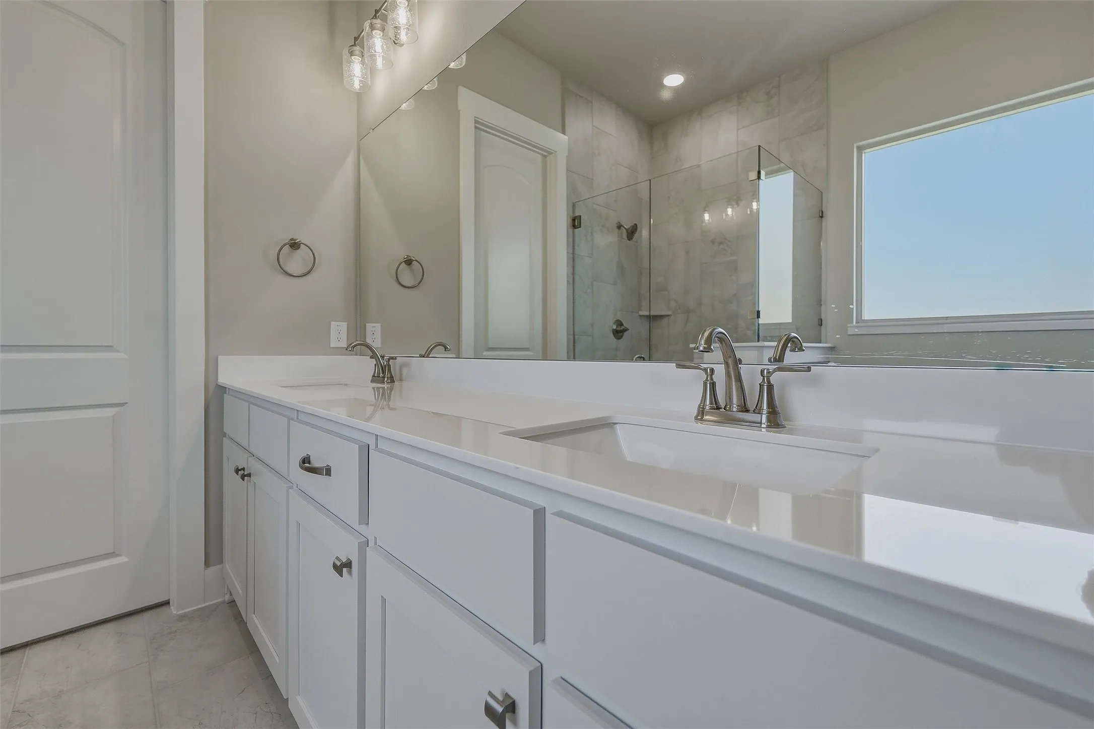 Dual vanity with undermount sinks, white cabinetry, and brushed nickel hardware