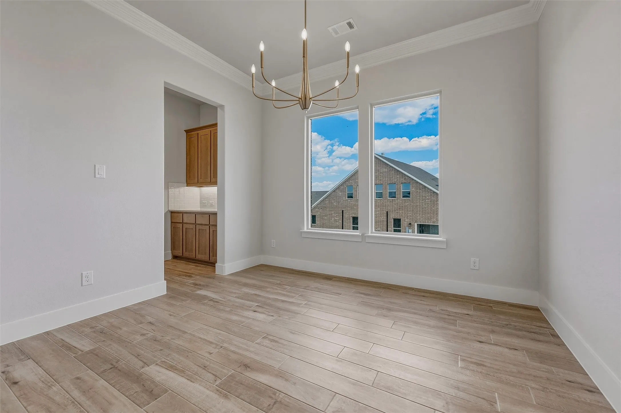 Recessed alcove with wood-finish cabinetry, under-cabinet lighting, and a white tile backsplash