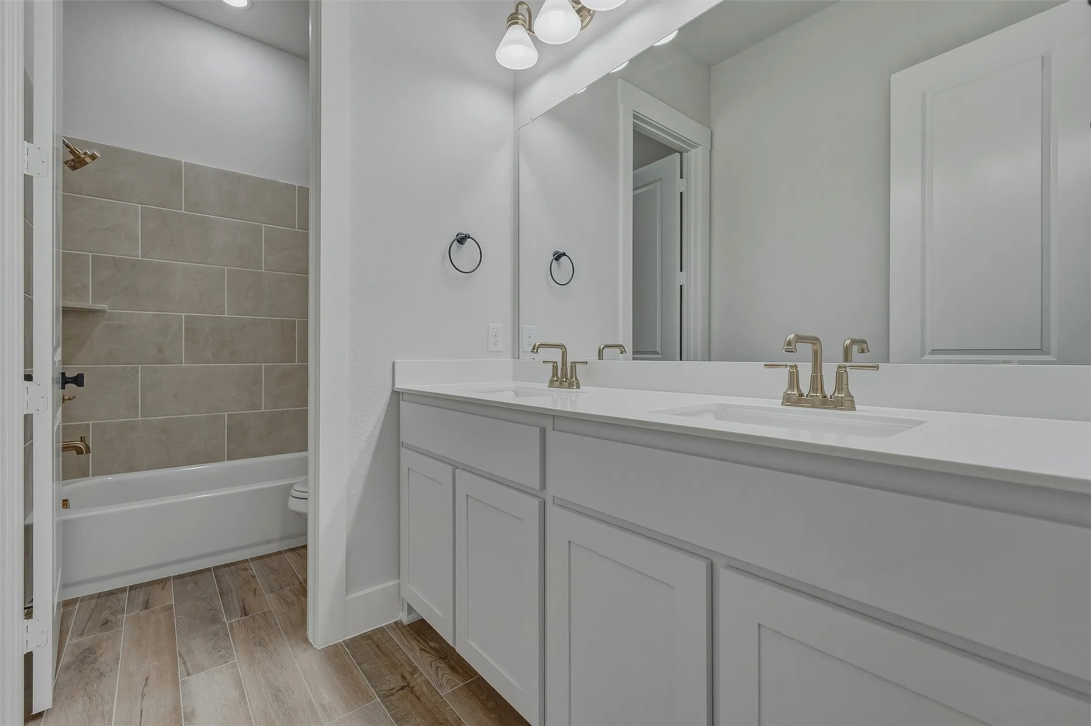 Dual vanity with integrated sinks, brushed nickel fixtures, and a large mirror