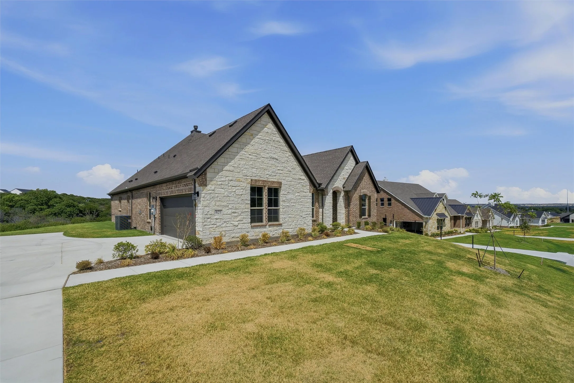 Stone and brick exterior with dark trim and a gabled roofline
