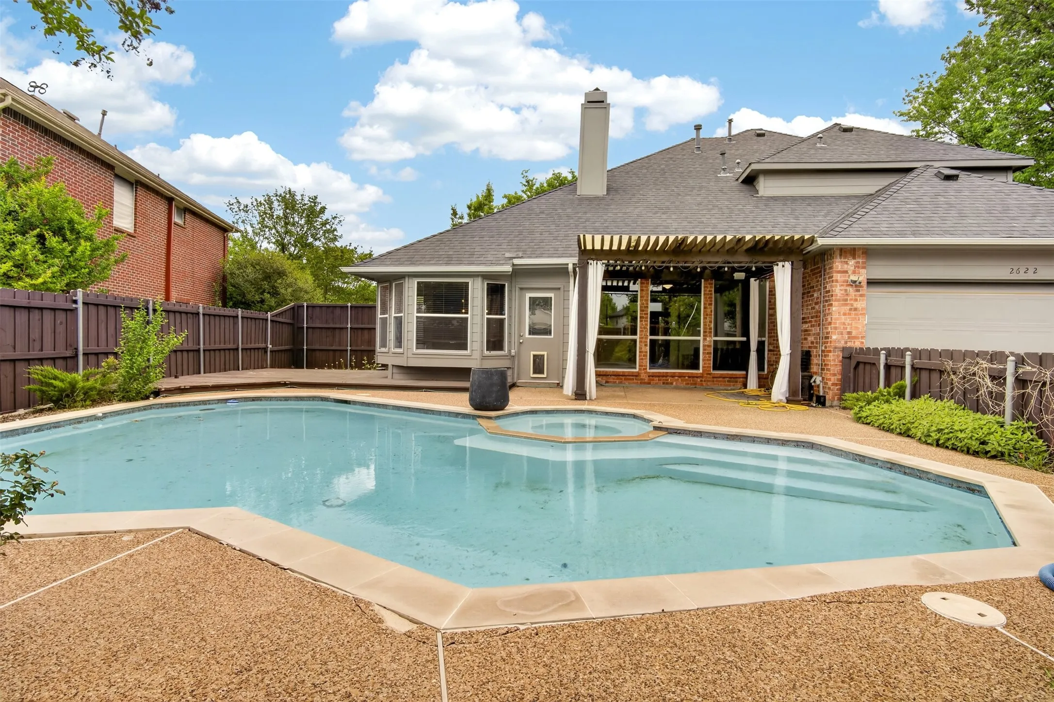 The property features a backyard with a pool, an integrated spa, and a surrounding patio