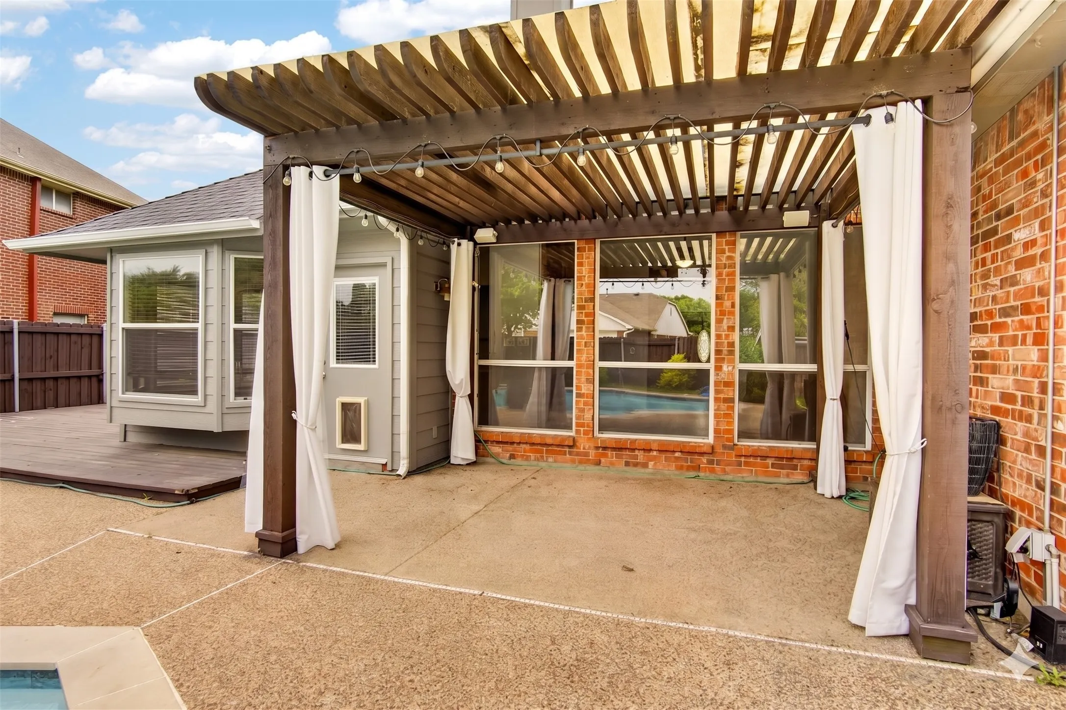 The property includes a spacious outdoor patio area, featuring a wooden pergola
