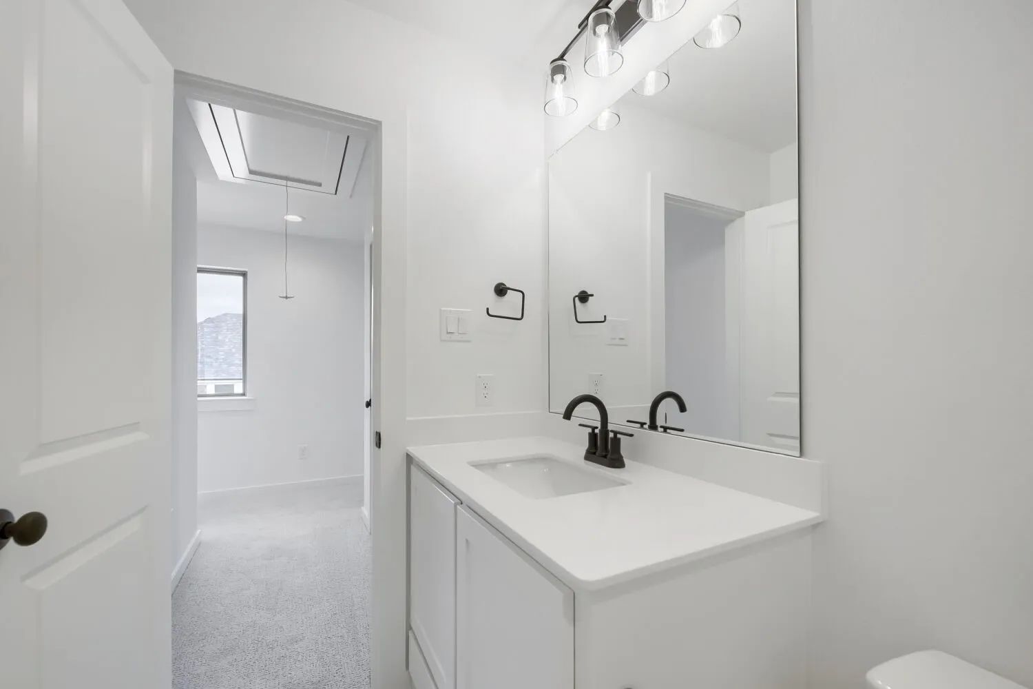 White vanity with an integrated sink and quartz countertop