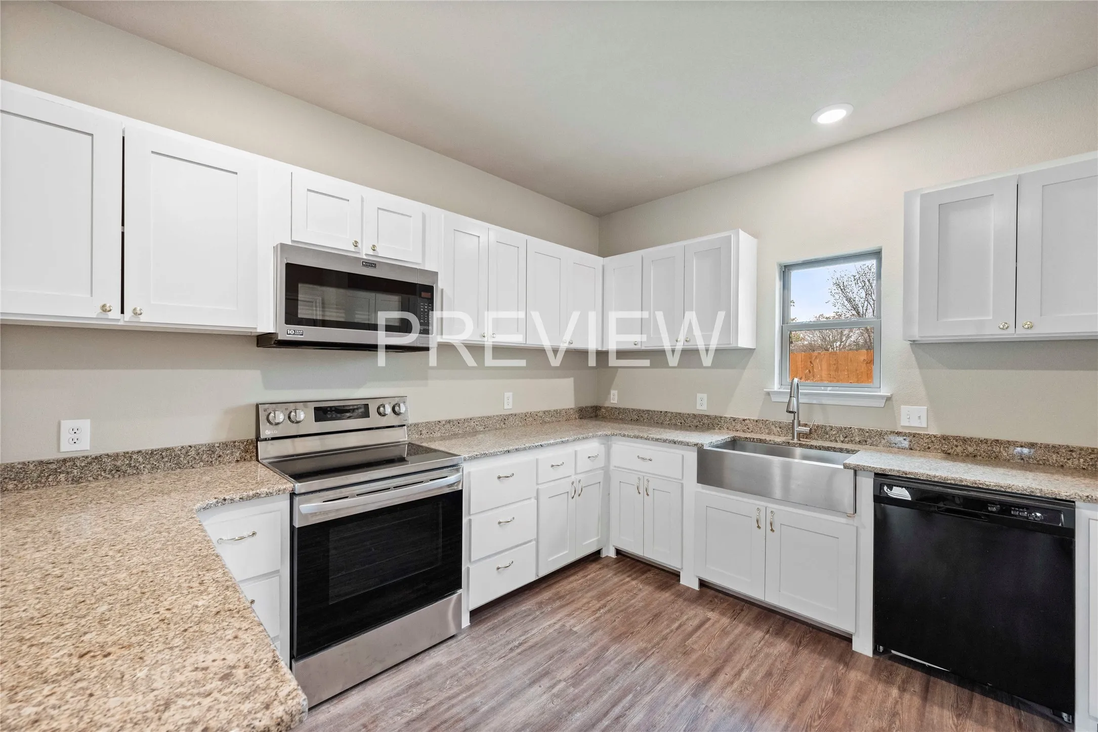 Modern kitchen featuring white shaker cabinetry, granite-style countertops, stainless steel appliances, a farmhouse-style sink with a gooseneck faucet, and wood-finish flooring