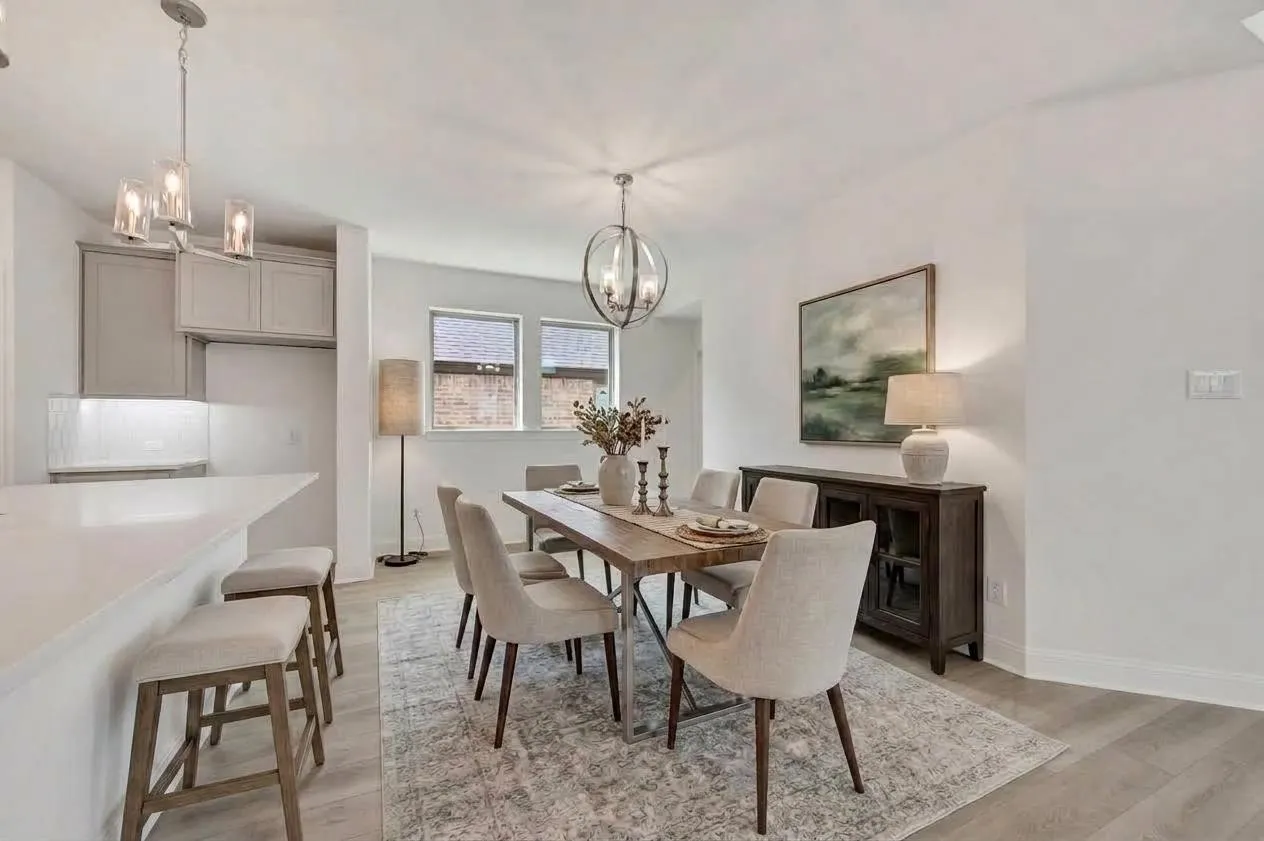 Spacious dining area with light-toned wood-finish flooring, two window openings, and a contemporary spherical chandelier