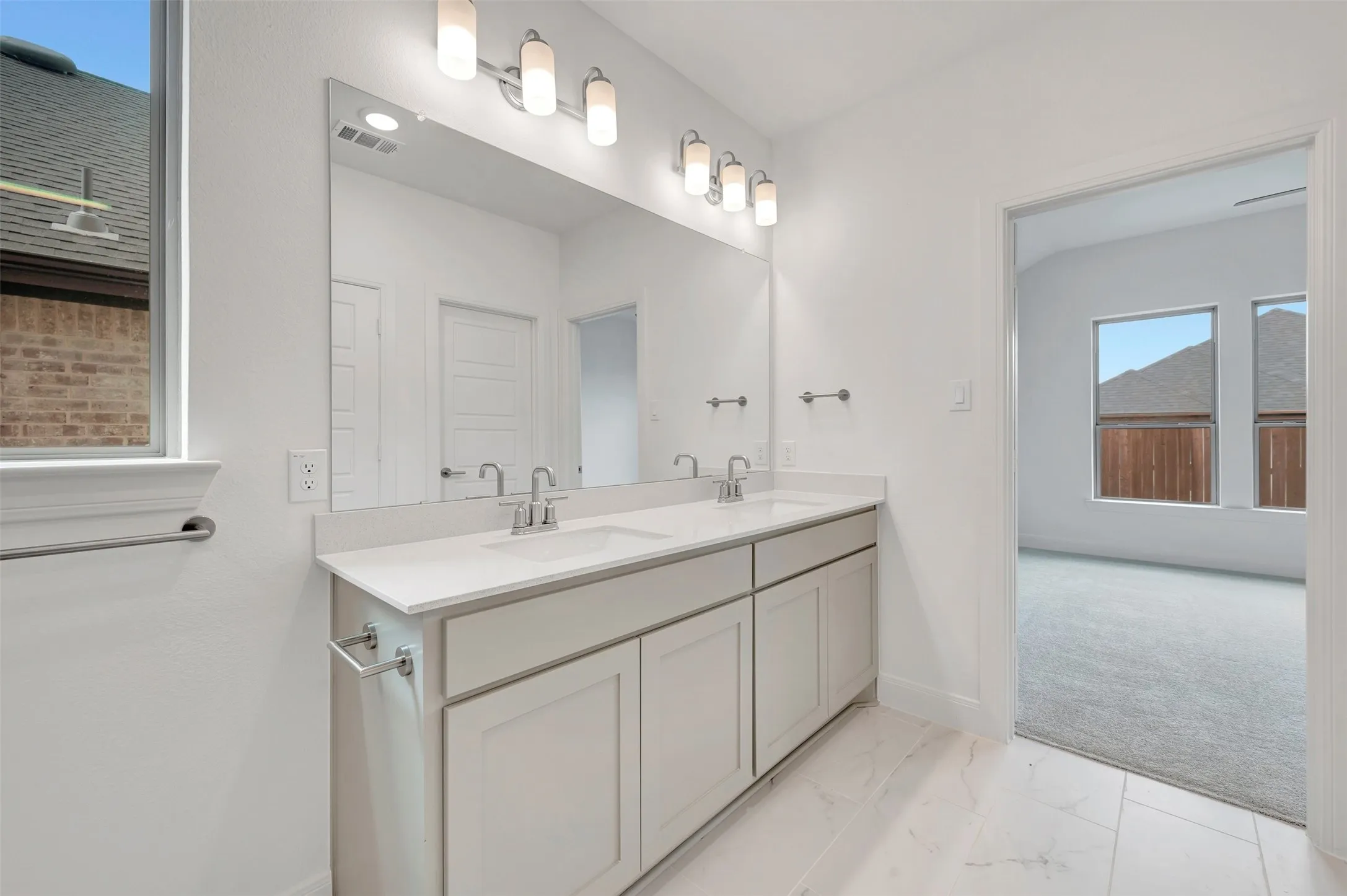 Dual vanity with white shaker-style cabinetry, white countertops, and chrome fixtures
