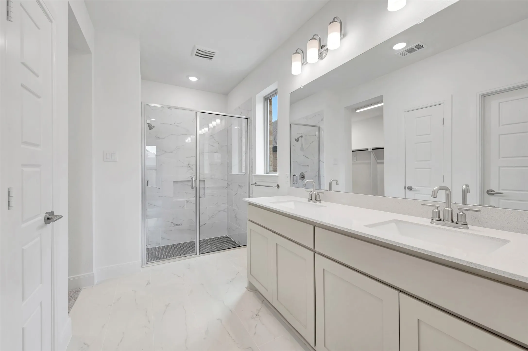 Dual vanity with undermount sinks, stone countertops, and chrome fixtures