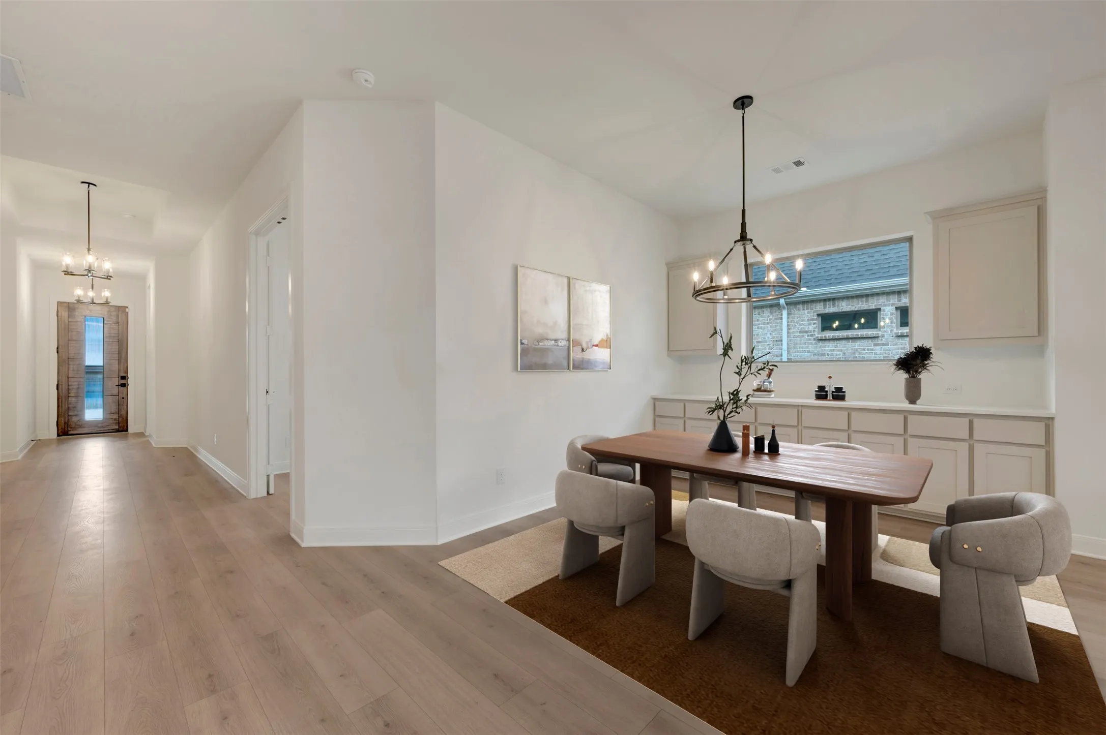 Wood-finish flooring throughout, recessed lighting, built-in cabinetry with integrated window, and a decorative chandelier
