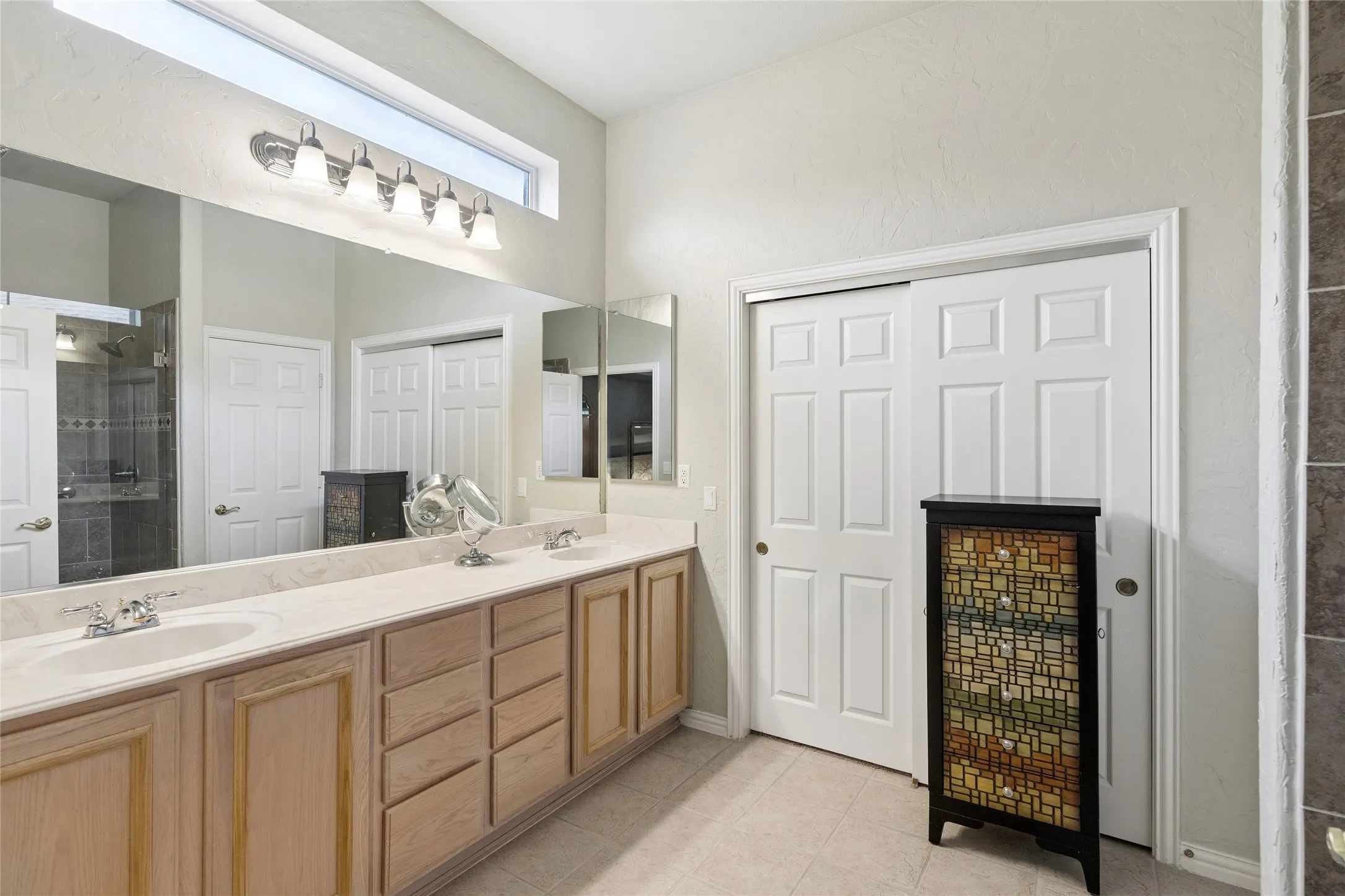 Ensuite bath with dual sinks, transom window allowing natural light to cascade in