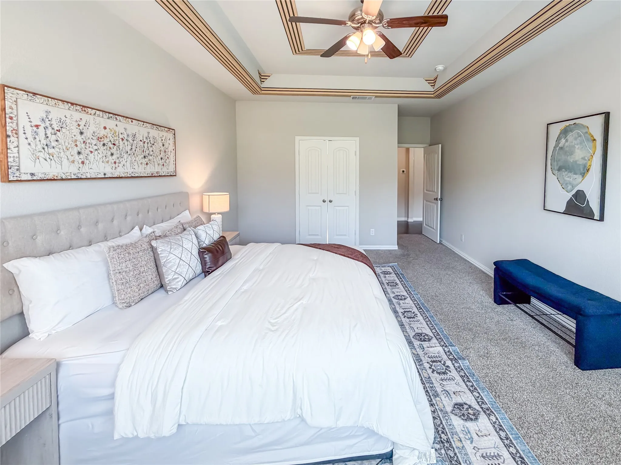 Tray ceiling with wood-finish accents and a ceiling fan