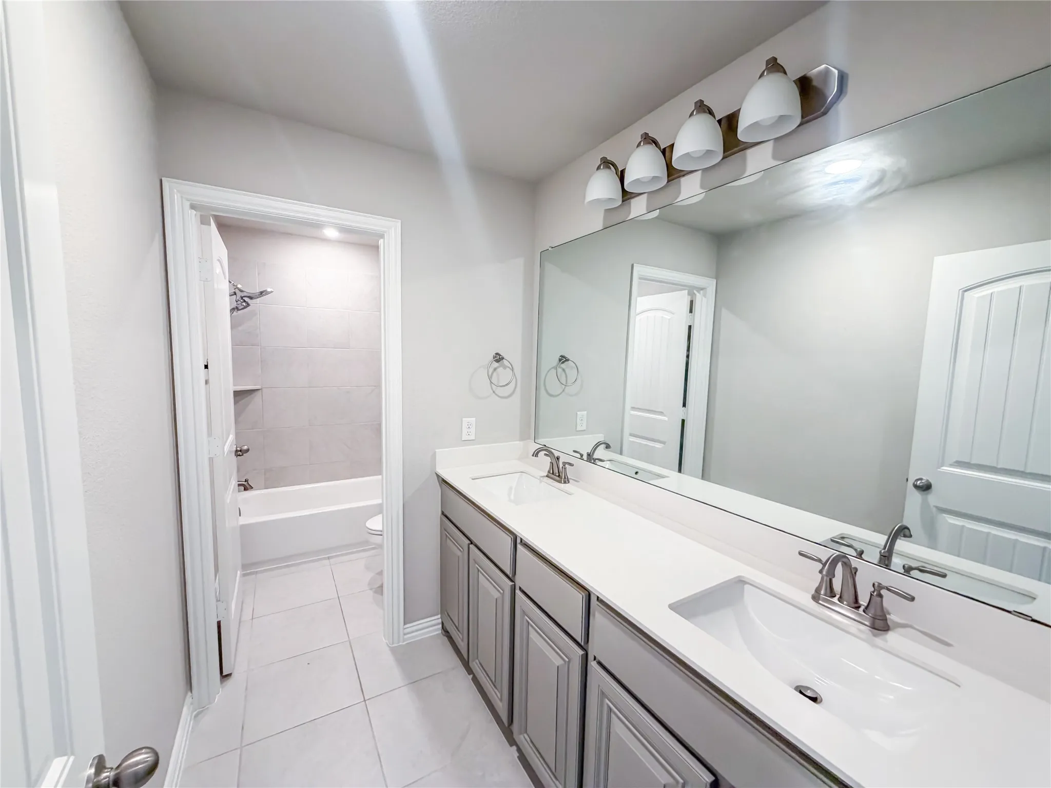Dual vanity with integrated sinks and brushed nickel fixtures
