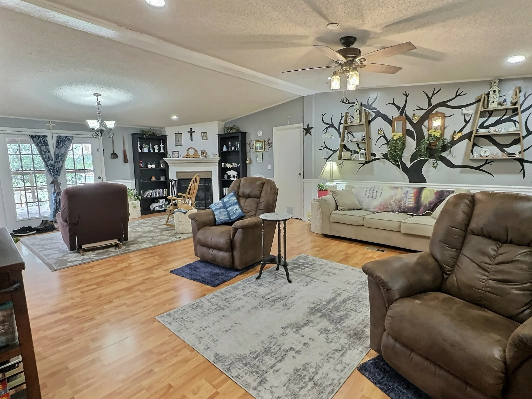 Spacious living area featuring wood-finish flooring, a fireplace with a mantel, and built-in shelving