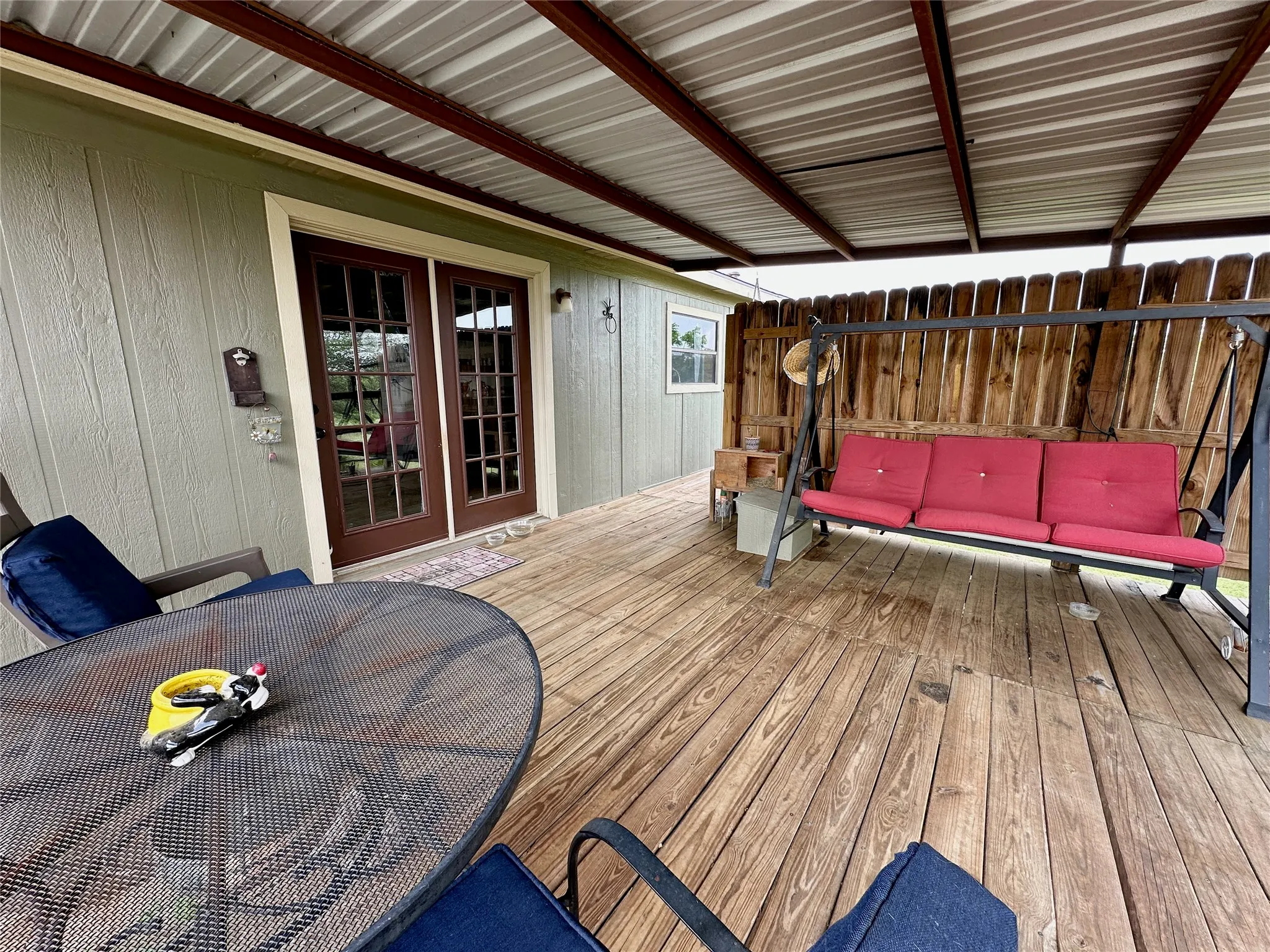 Expansive outdoor deck featuring wood-finish flooring and a covered metal roof