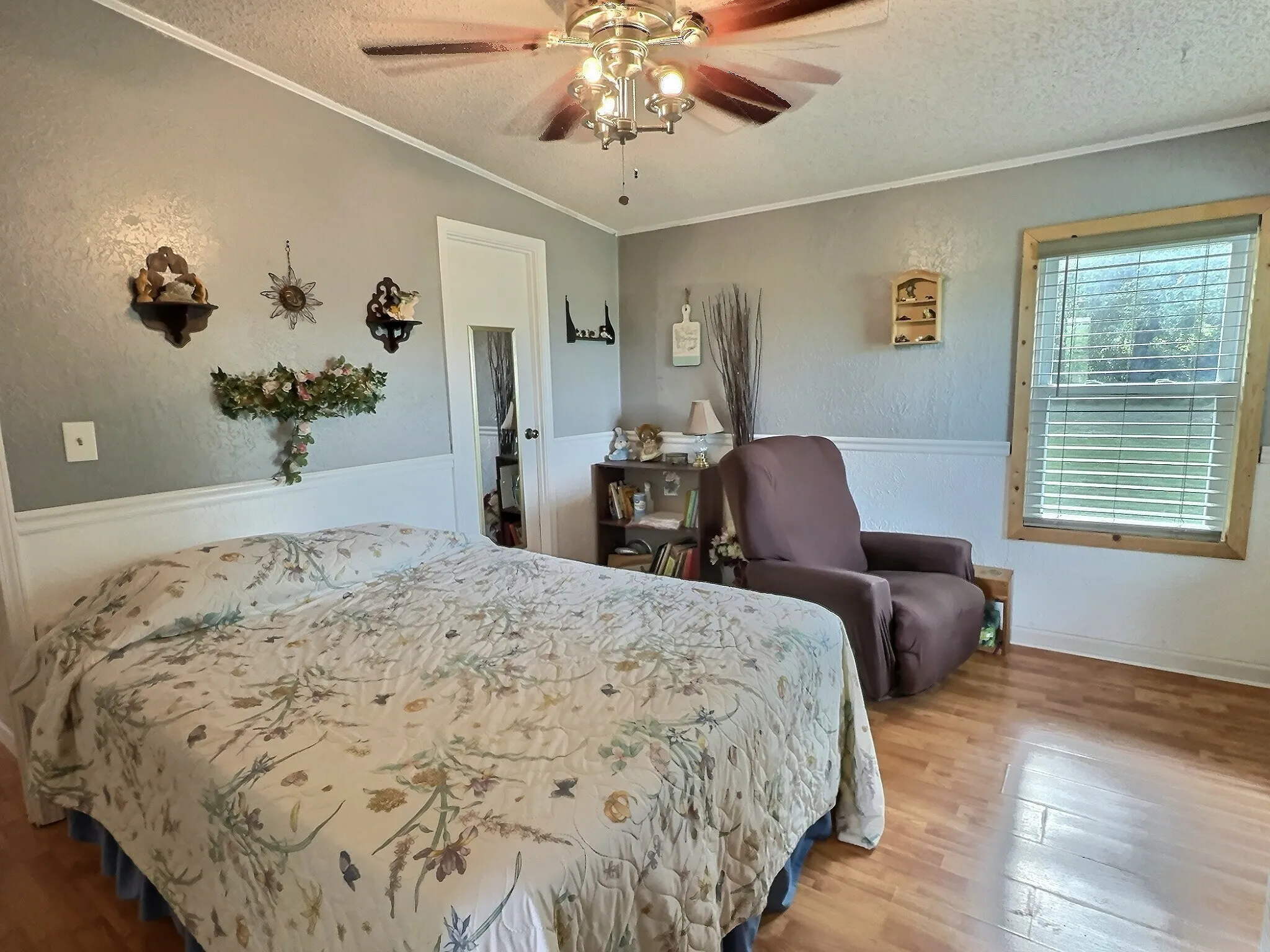 Room featuring wood-finish flooring and a ceiling fan with integrated lighting