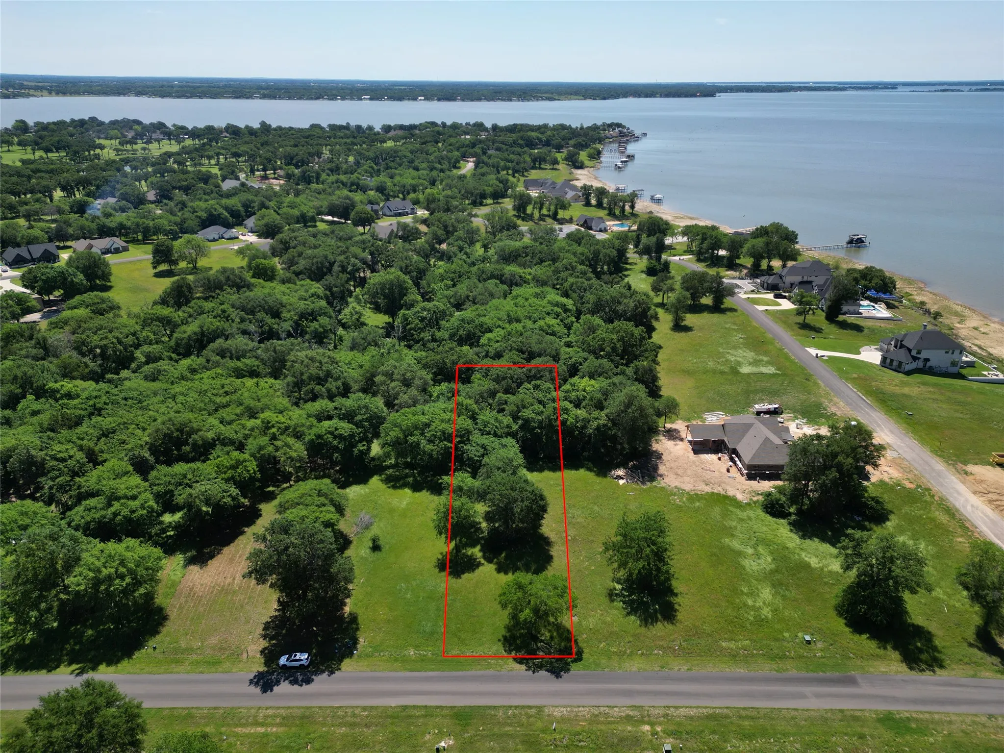 Partially cleared land parcel with mature trees and direct road frontage