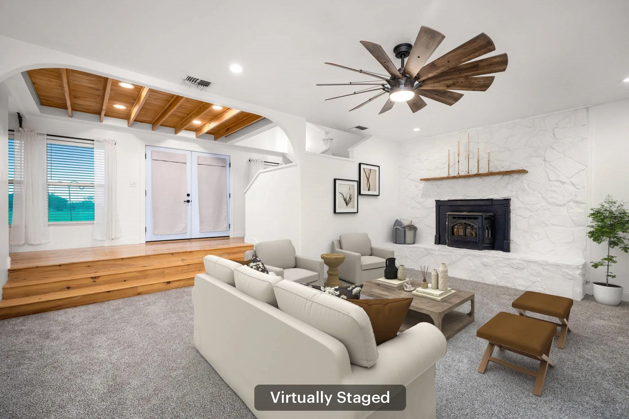 Virtually Staged, Living area featuring a white painted stone fireplace with a black insert, wood mantel, and wood-finish ceiling fan