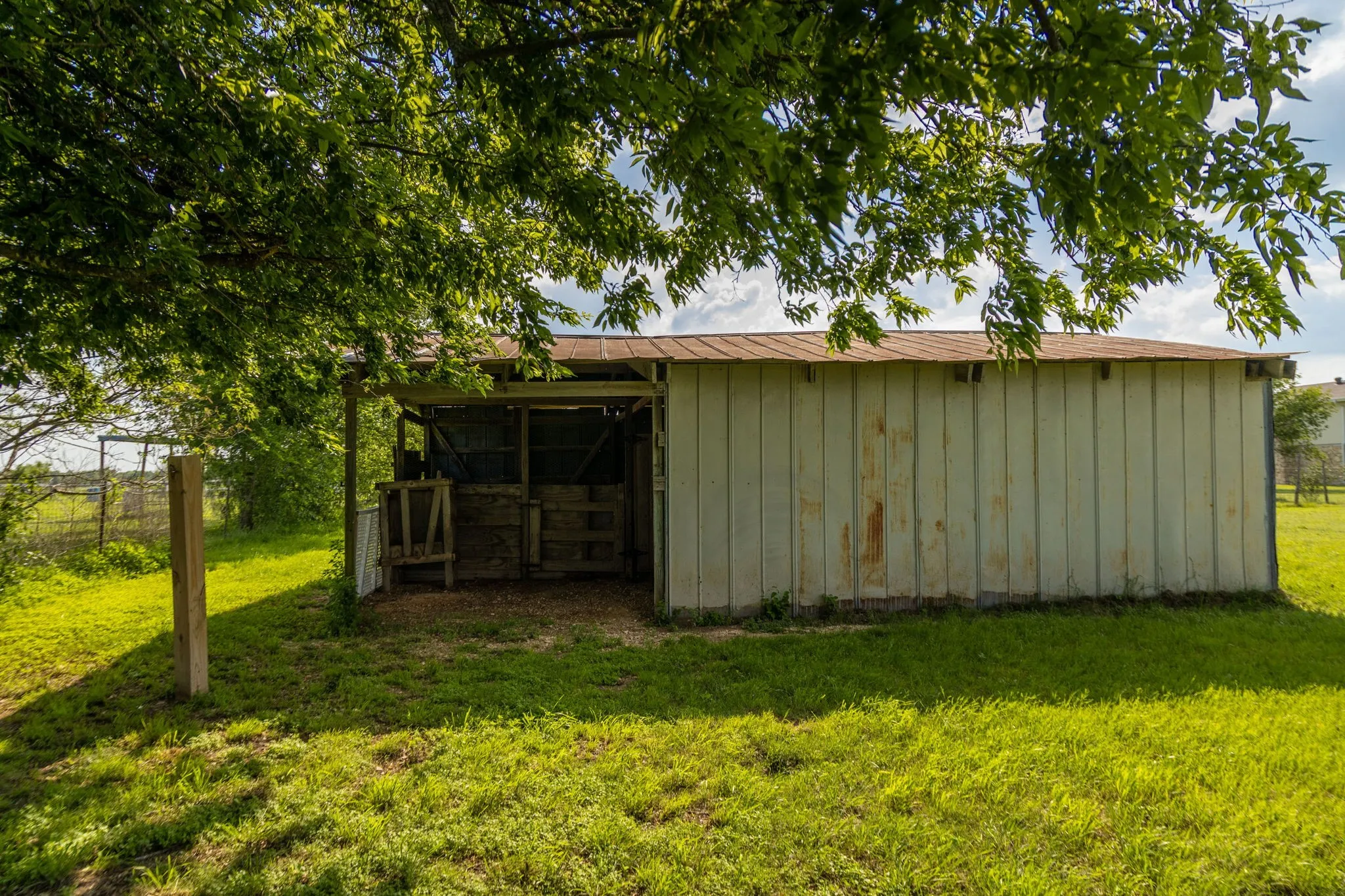 Outbuilding with board and batten siding and a sheltered open-air stall