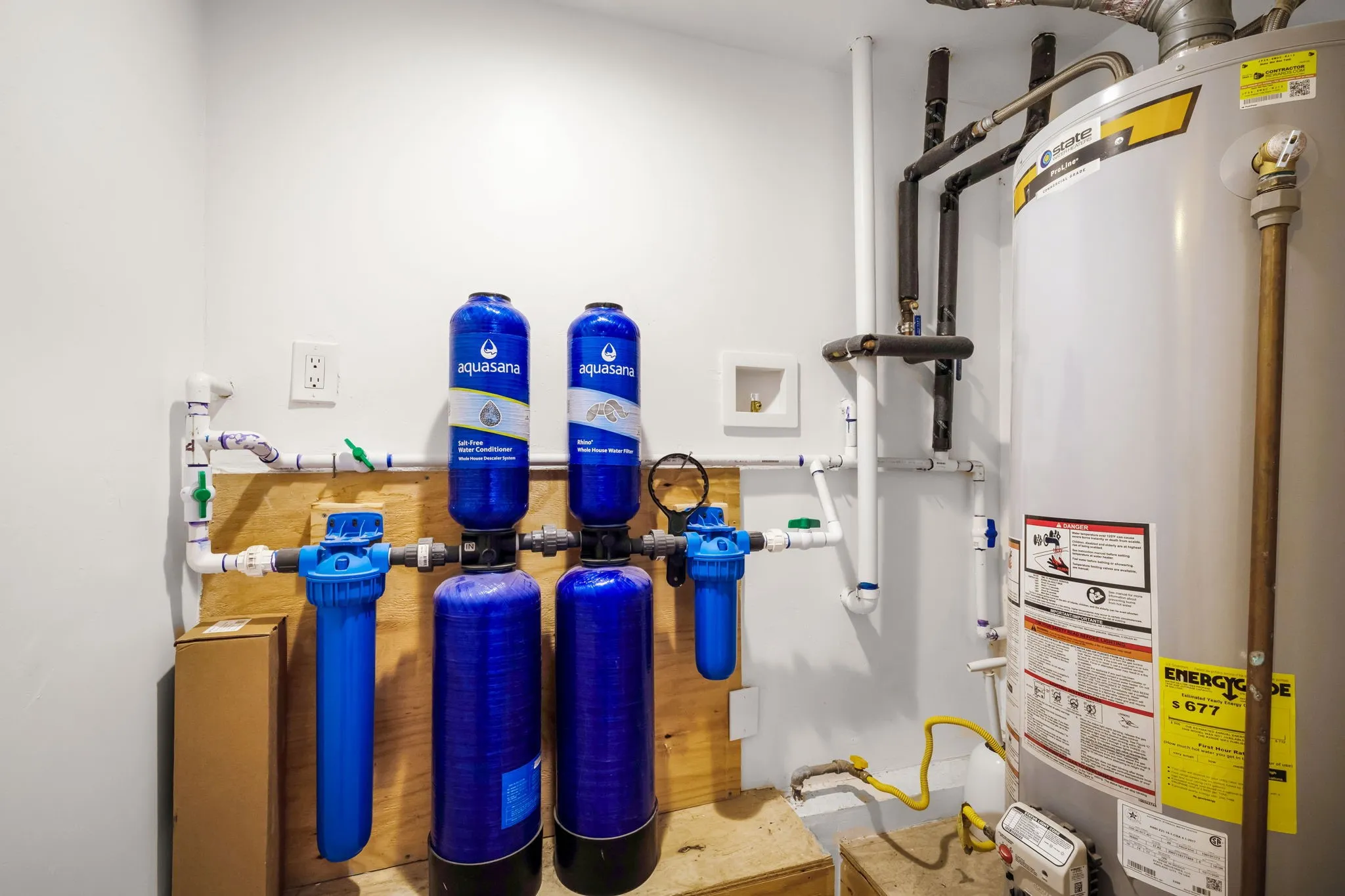 Water heater and whole-home water filtration system installed on a light-toned wall