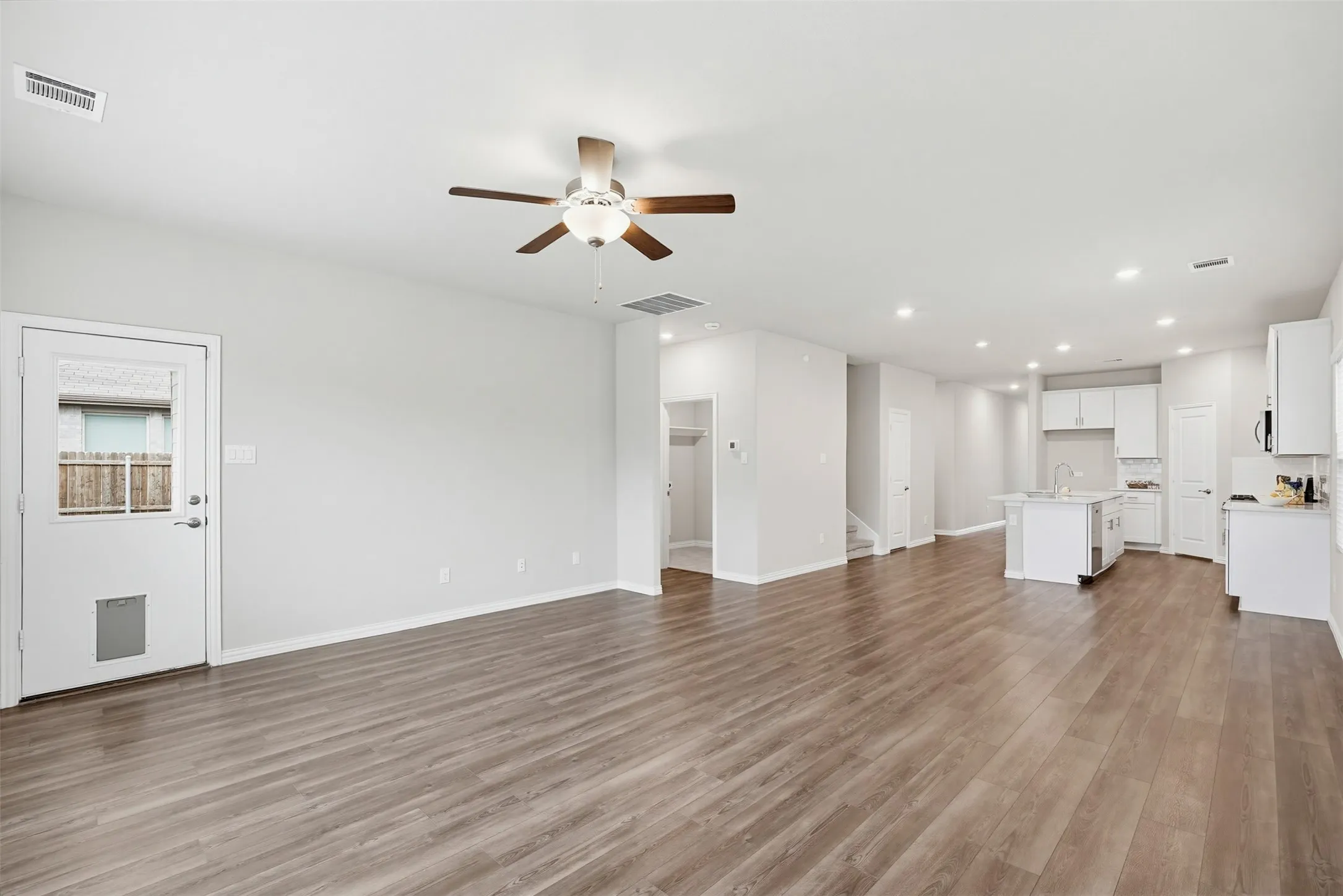 Spacious living room open to the dining area and kitchen, filled with natural light and designed for comfortable living and entertaining.