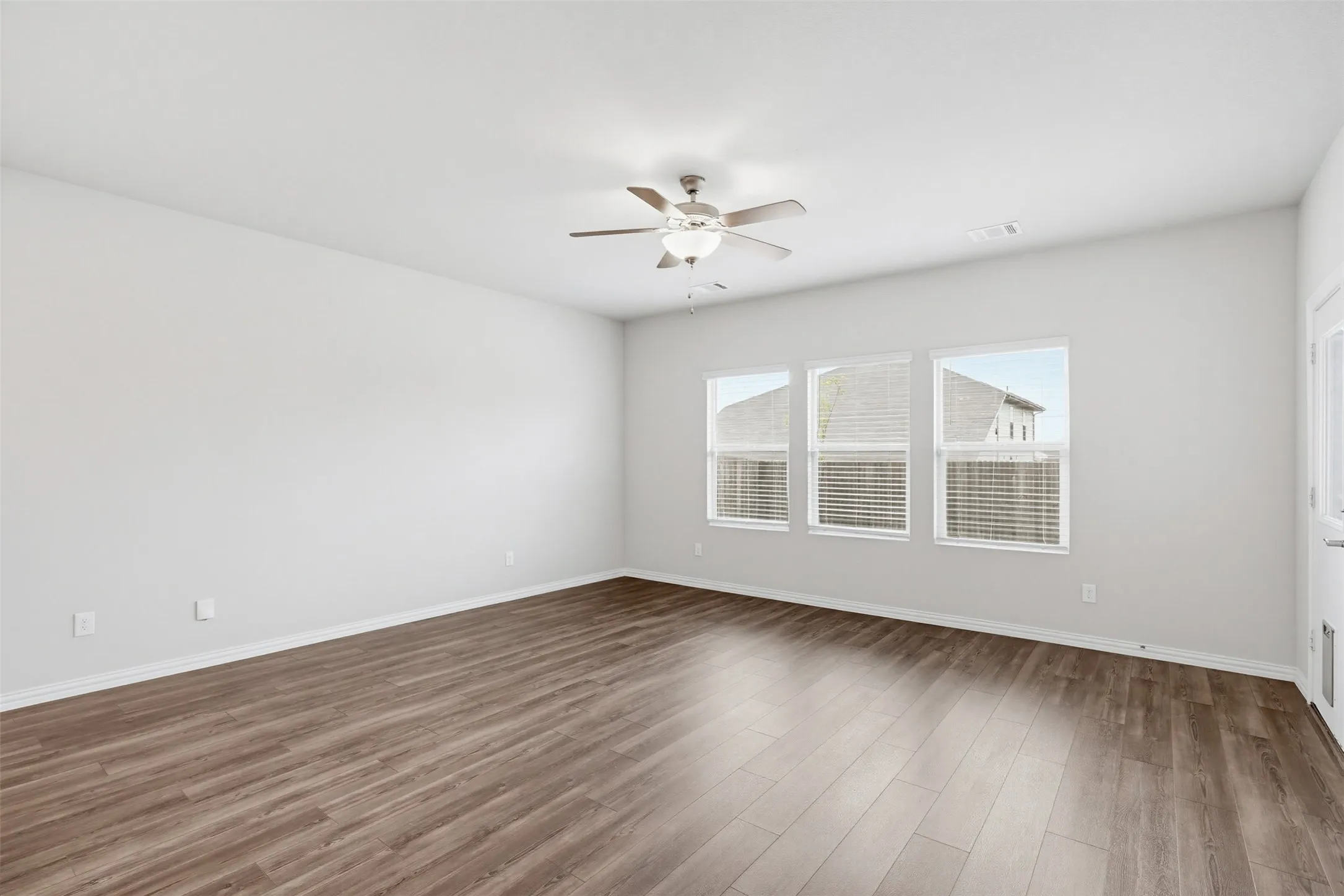 Spacious living room open to the dining area and kitchen, filled with natural light and designed for comfortable living and entertaining.