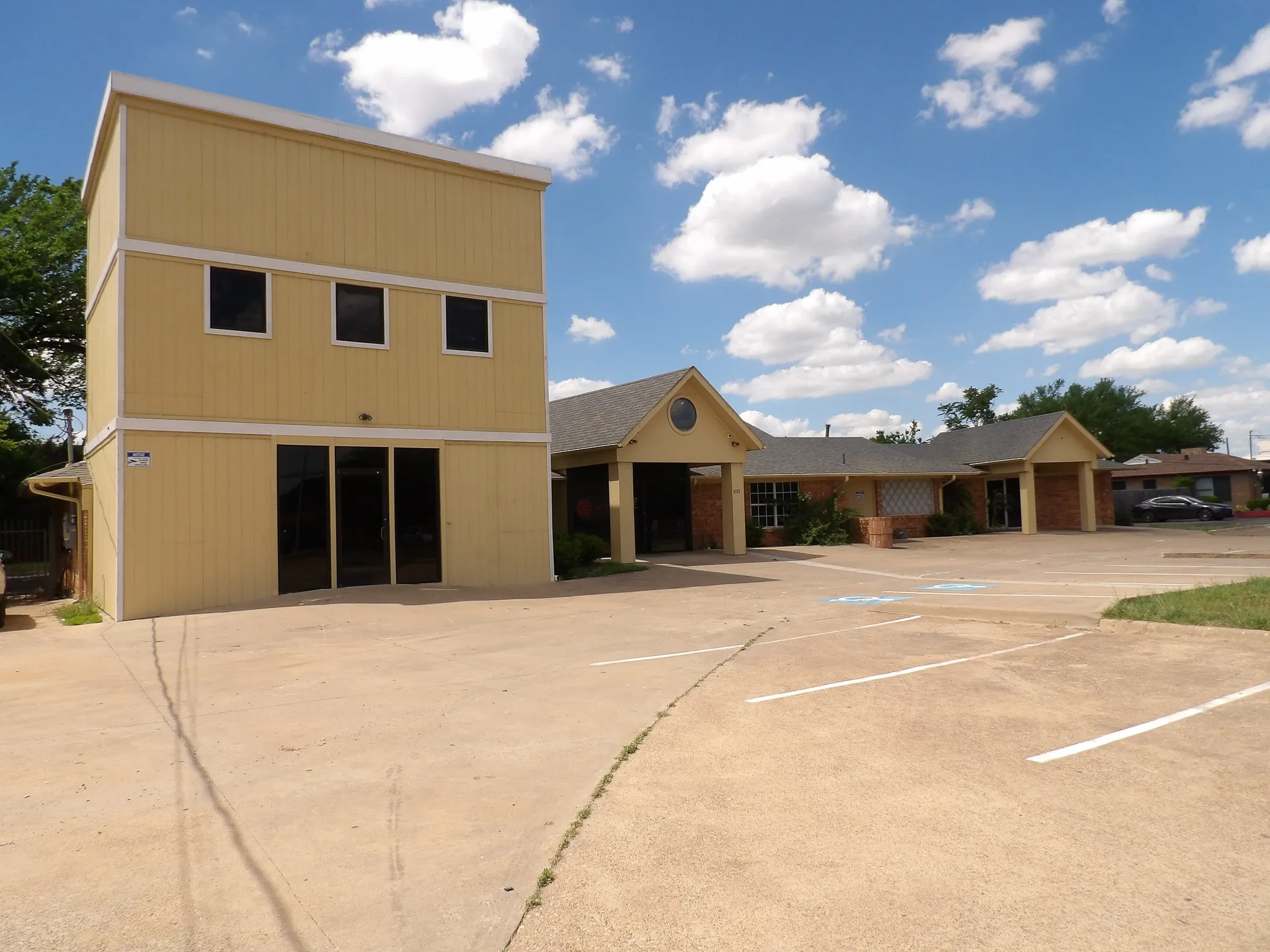 Multi-building commercial property featuring a three-story structure with a ground-level glass storefront