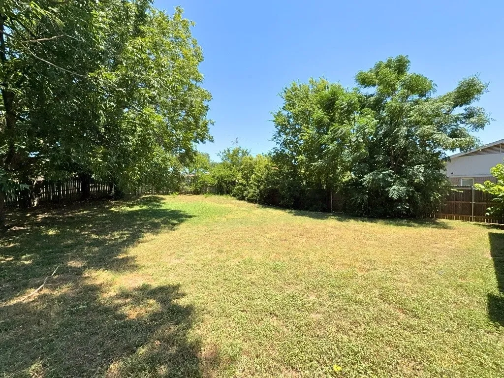 Fenced backyard with mature trees