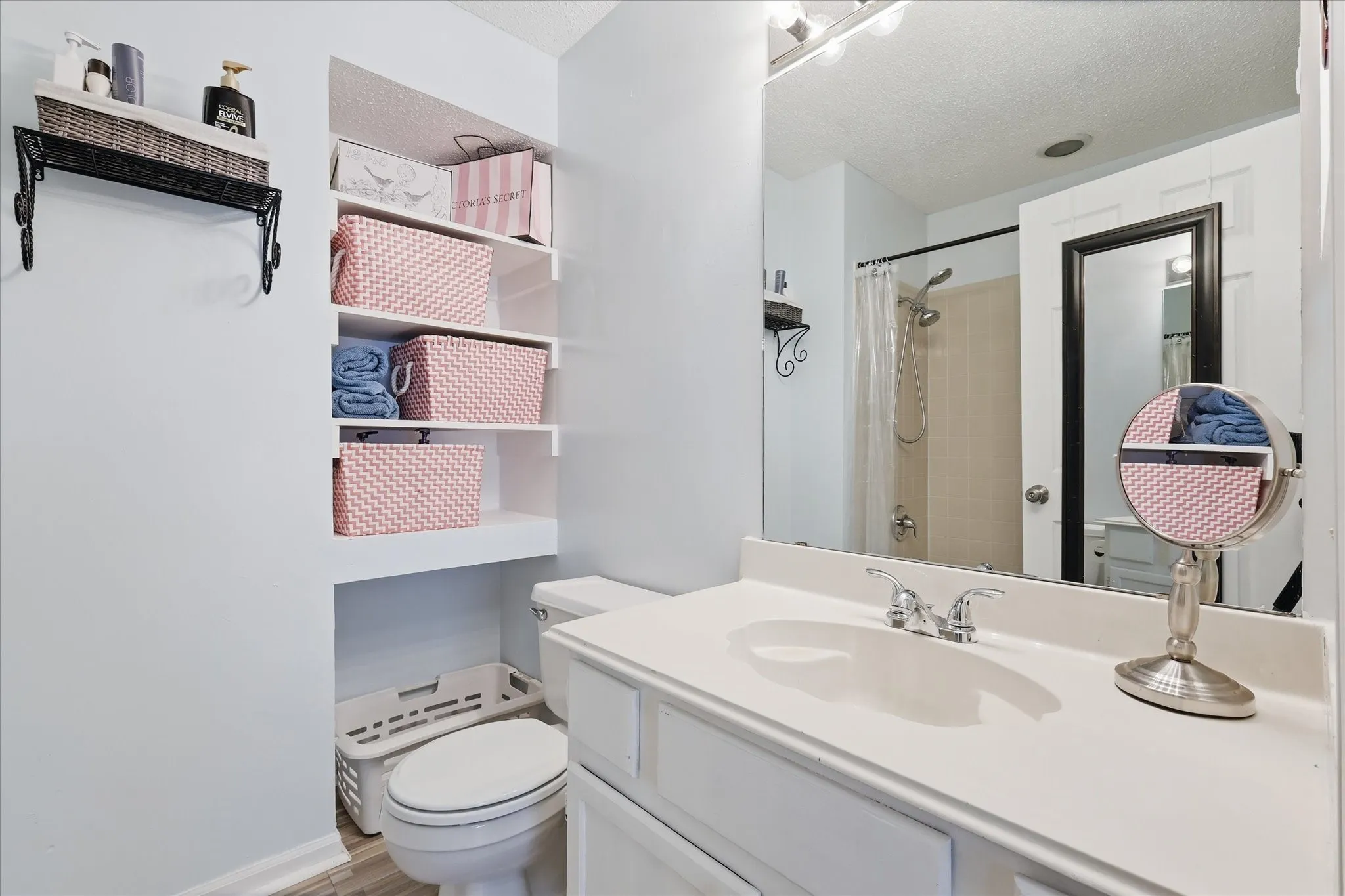 Bathroom featuring a white vanity with integrated sink, chrome-finish faucet, and a large wall-mounted mirror