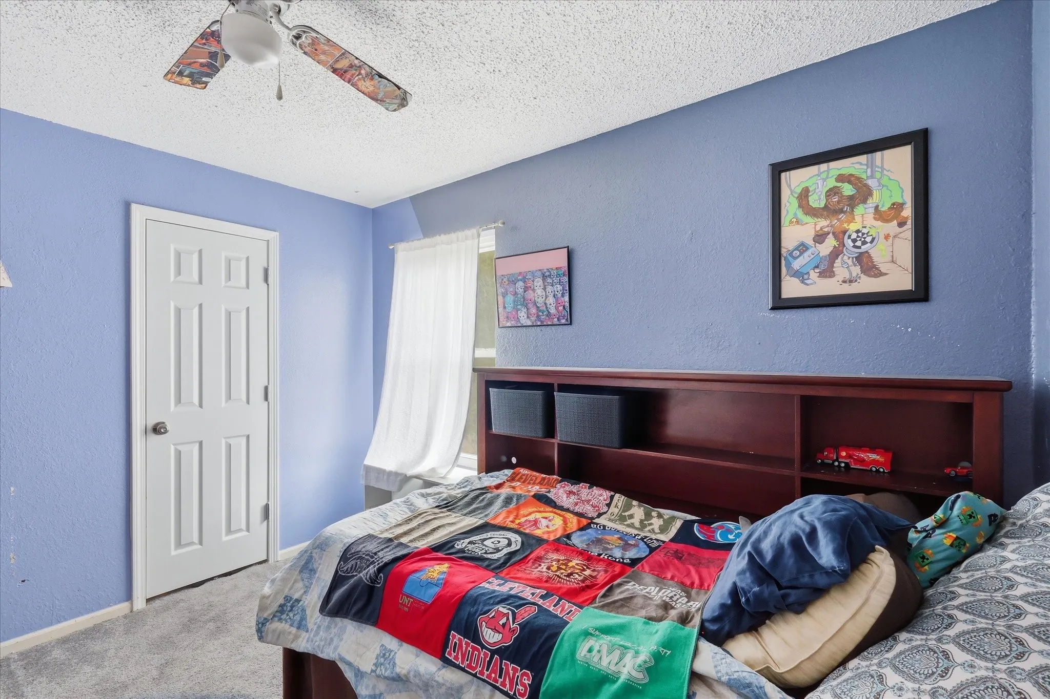 Bedroom featuring textured blue walls and a white six-panel door