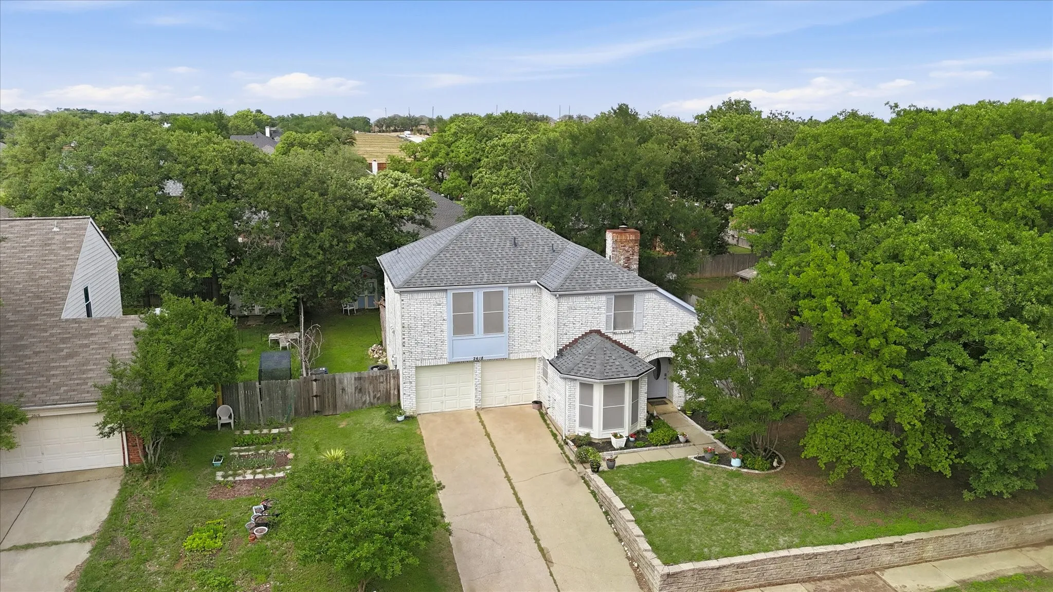 Two-story residence with a light-colored brick exterior and a contrasting light blue accent on the upper level