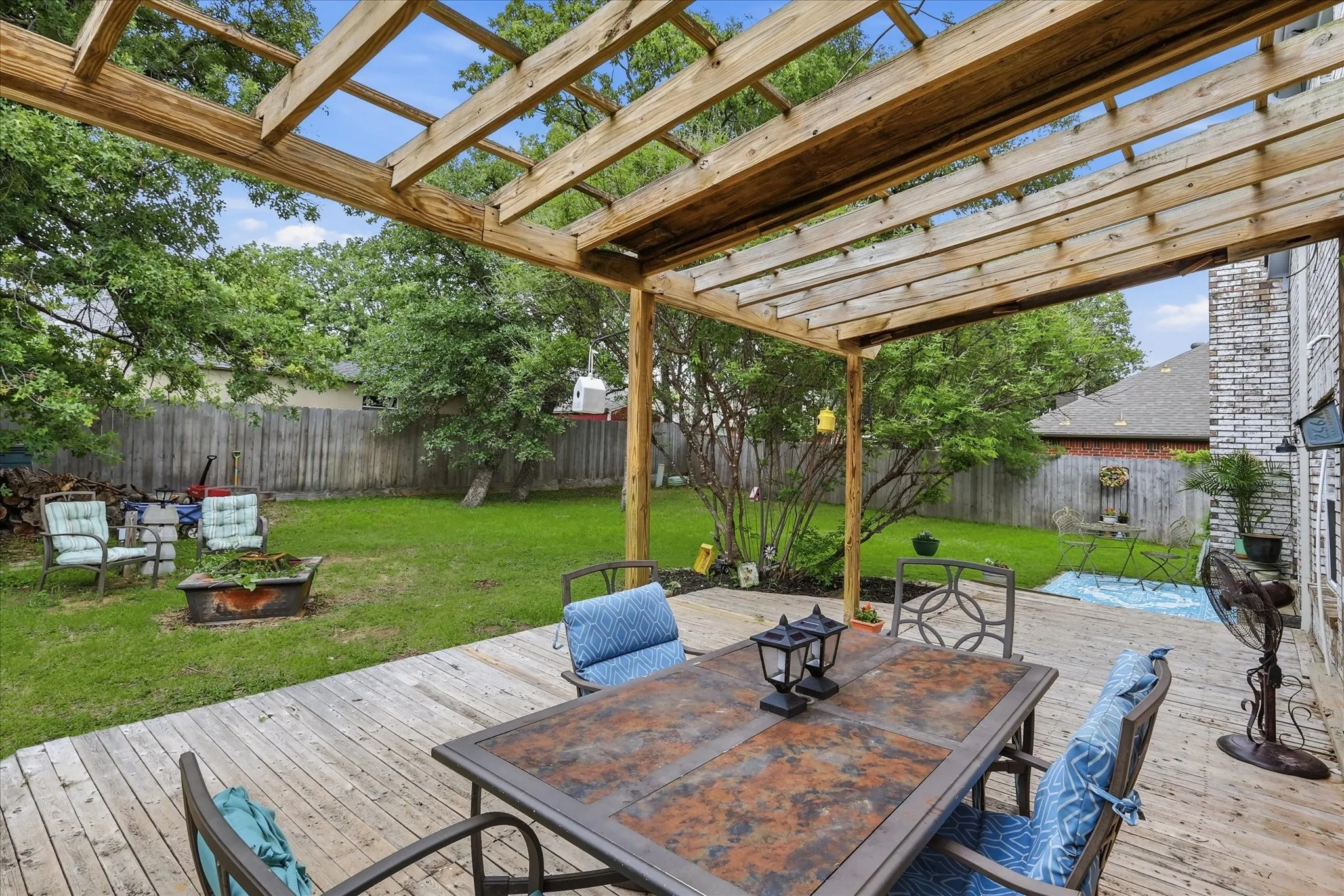 Spacious outdoor living area featuring a wooden pergola and expansive deck
