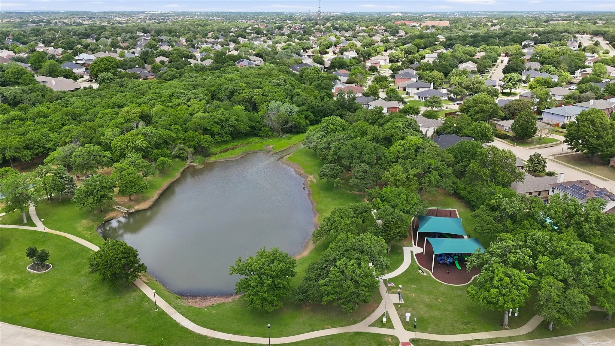 Community park featuring a central pond with surrounding pathways