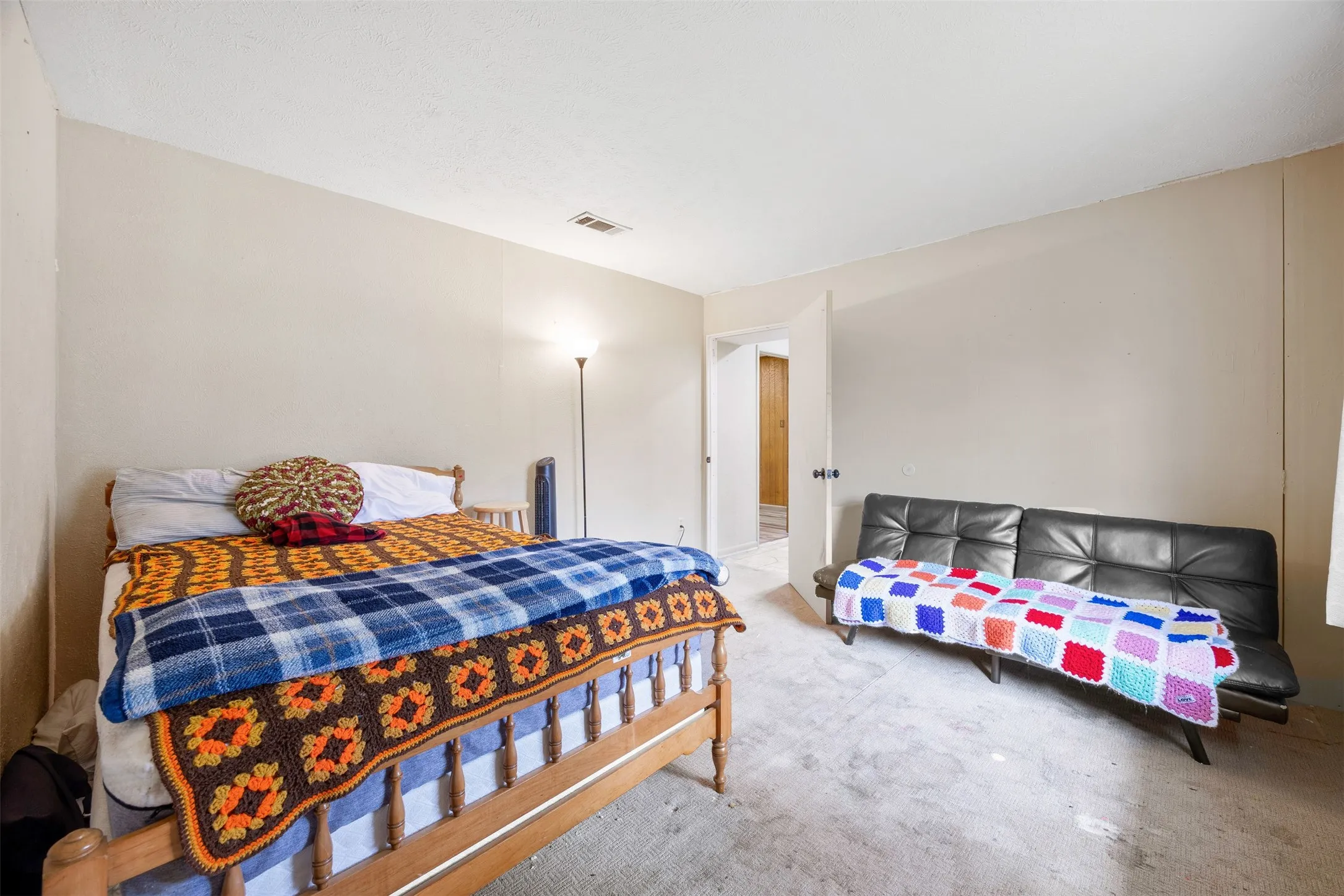 Neutral-toned walls complement the light-colored carpeting throughout this bedroom space
