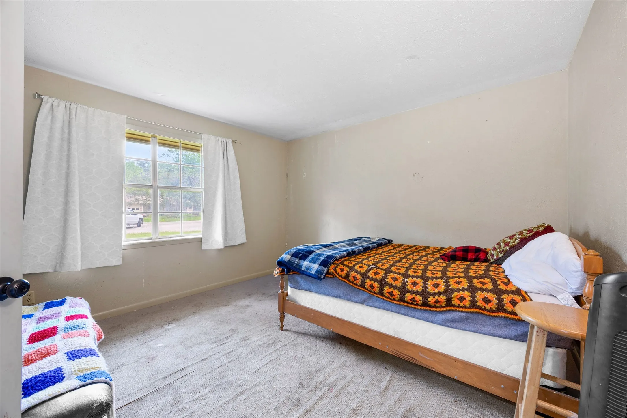 Room with light beige walls and grey carpet flooring