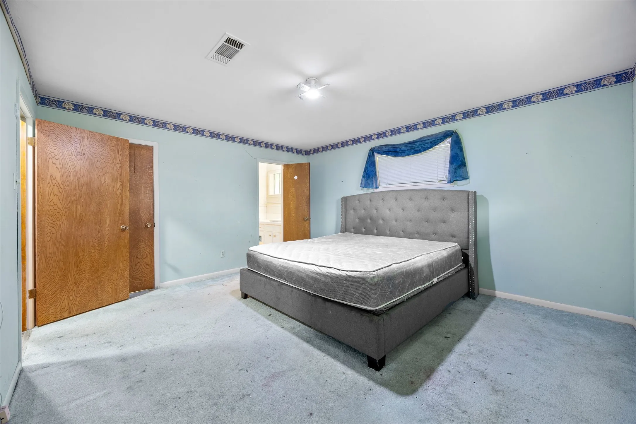 Room with light blue walls, light blue carpeting, and white ceiling with a central lighting fixture